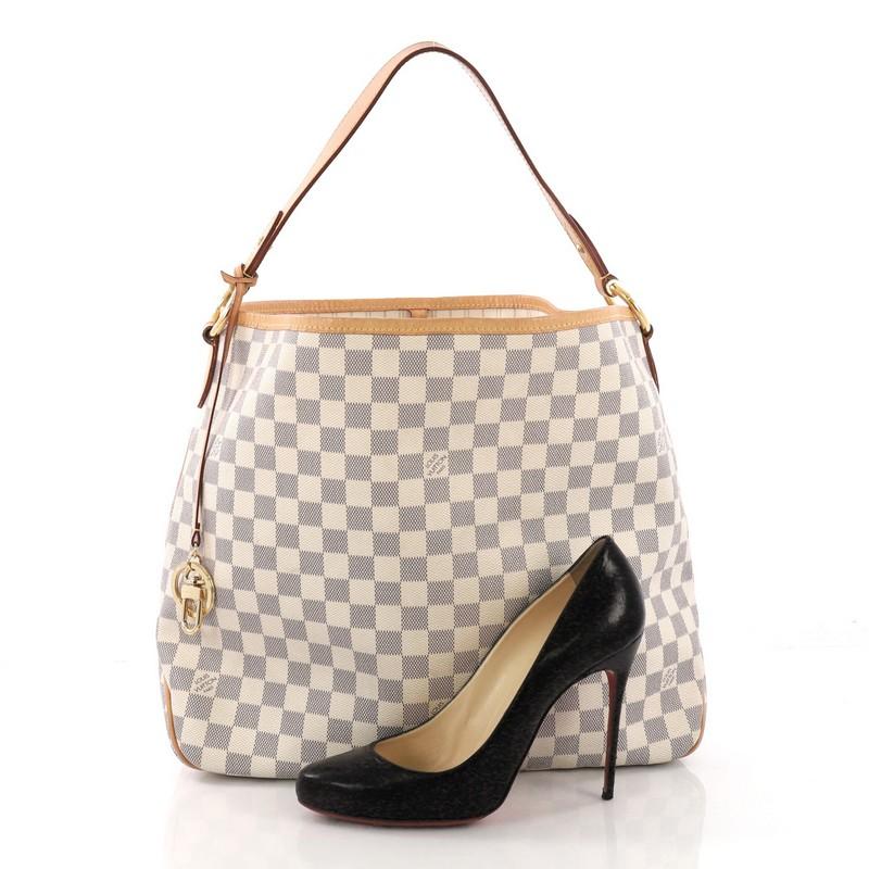 This Louis Vuitton Delightful NM Handbag Damier MM, crafted in damier azur coated canvas, features a flat leather handle, cowhide leather trims, and gold-tone hardware. Its hook closure opens to a beige fabric interior with zip pocket. Authenticity