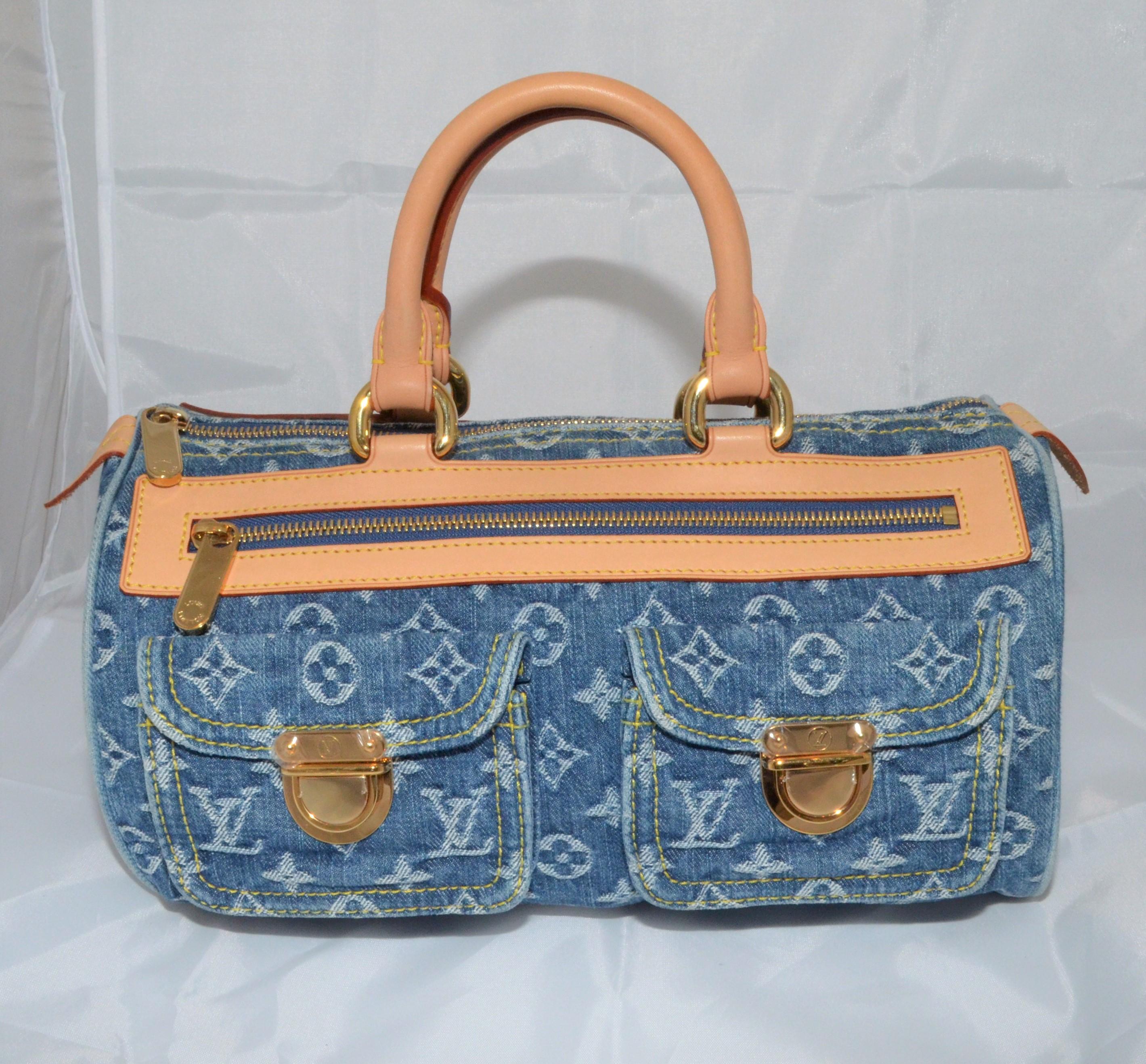 Louis Vuitton handbag featured in blue denim with a signature monogram design, top leather handles, zipper fastening, and two functional flap pockets at the front. Gold-tone hardware throughout. Interior is fully lined in a mustard-yellow suede