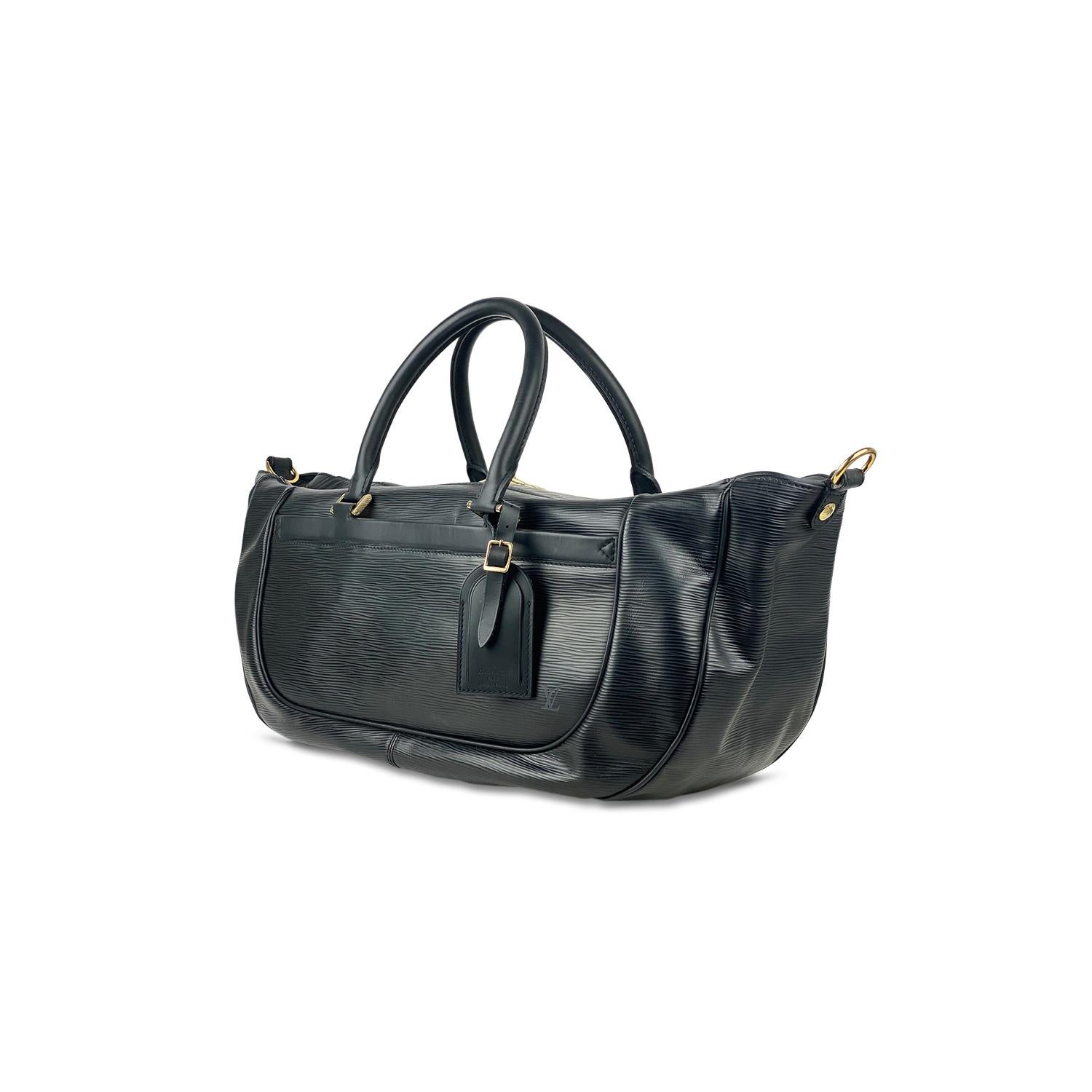 Black Epi leather Louis Vuitton Dhanura GM with

- Brass hardware,
- Single flat optional adjustable shoulder strap
- Dual rolled top handles
- Dual slit pockets at front face and back, tonal canvas lining, single slit pocket at interior wall and