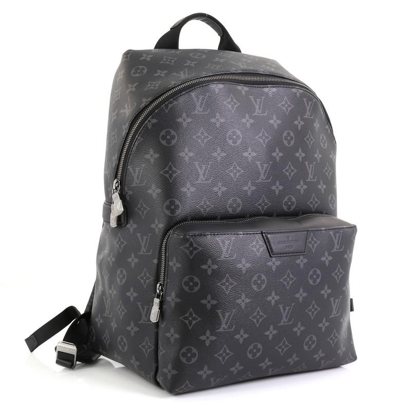 This Louis Vuitton Discovery Backpack Monogram Eclipse Canvas PM, crafted in black monogram eclipse coated canvas, features dual leather shoulder strap, exterior front zip pocket and gunmetal-tone hardware. Its zip closure opens to a black fabric