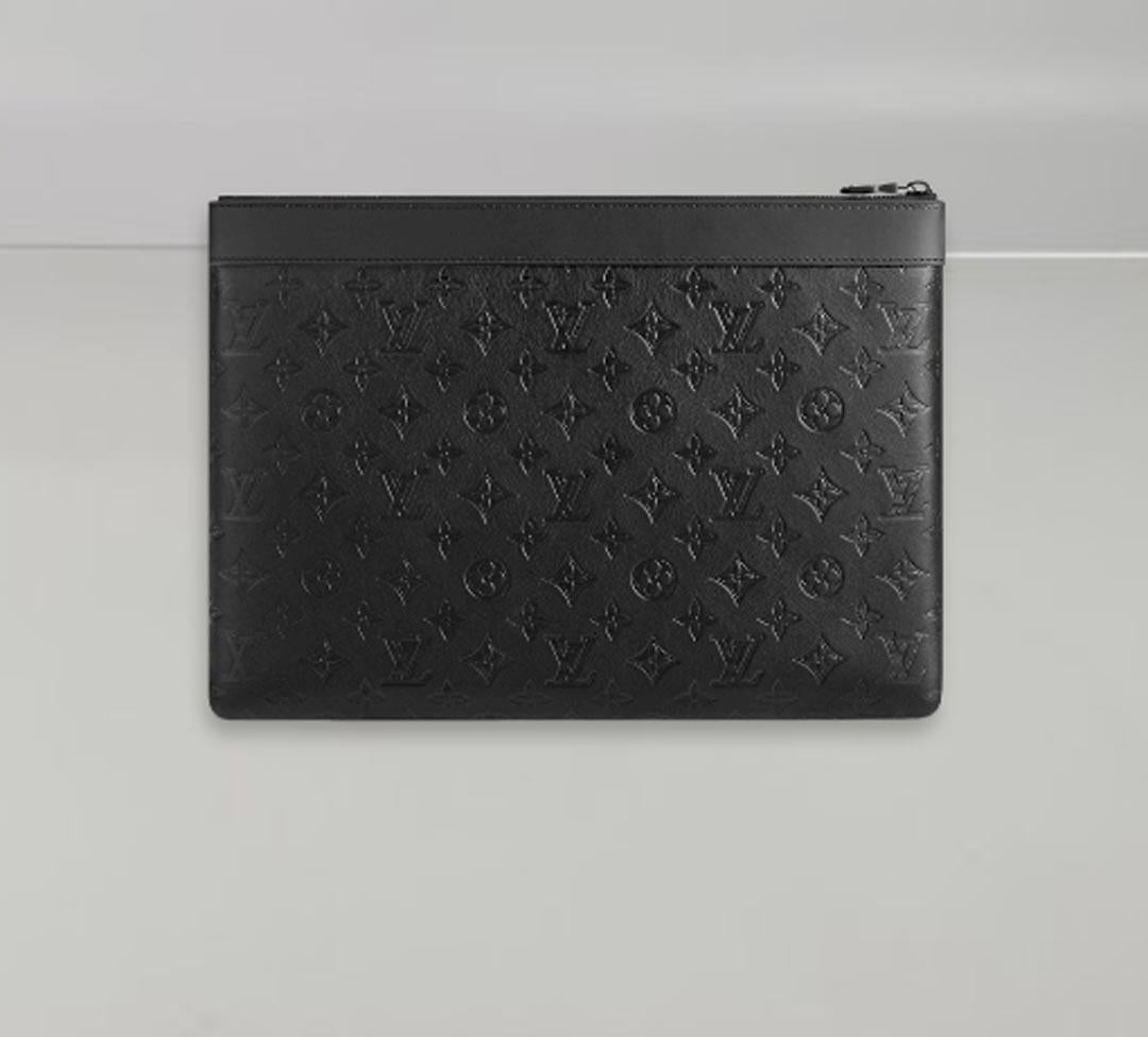 Crafted from black Monogram Shadow calfskin, an exceptionally supple leather discreetly embossed with Louis Vuitton's iconic Monogram pattern, the Discovery Pochette is an elegant way to carry documents and other essentials. This sleek pouch with
