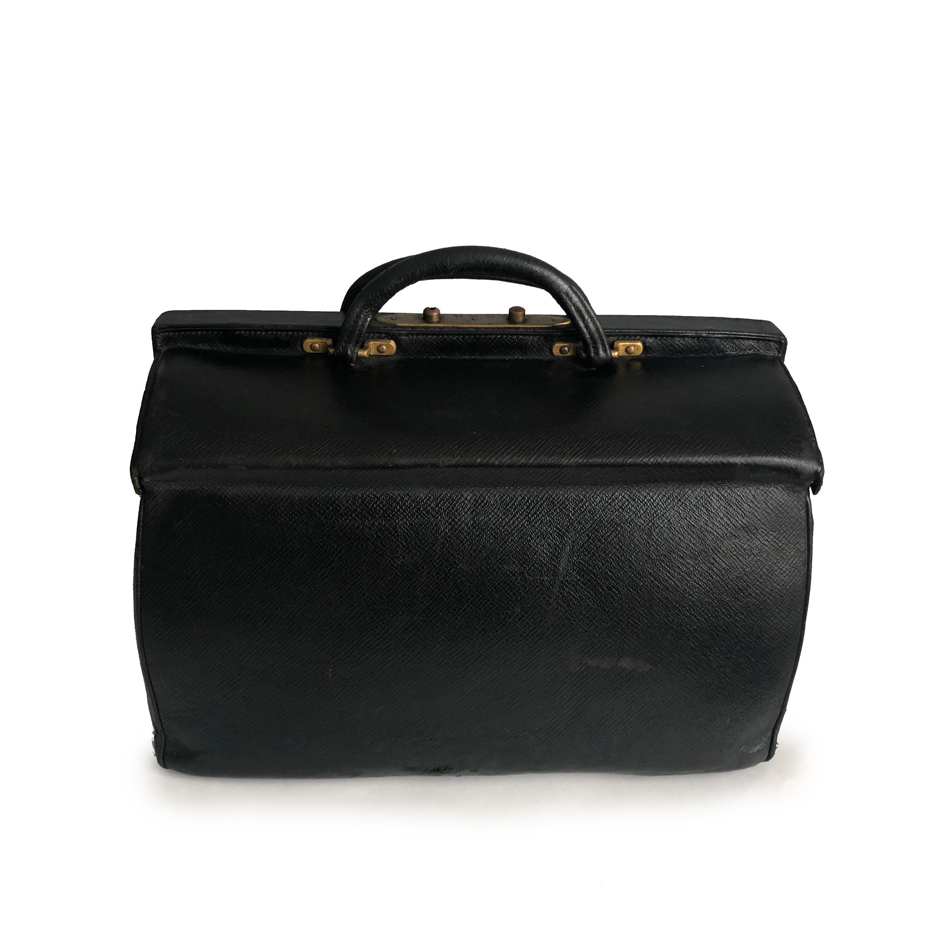 Antique Louis Vuitton Sac Cabine Black Doctors Bag, likely made in the early 20th C.  Made from black textured grain leather, it opens like a doctor's bag with two hinged pieces and features double top handles.  It's lined in red leather with two