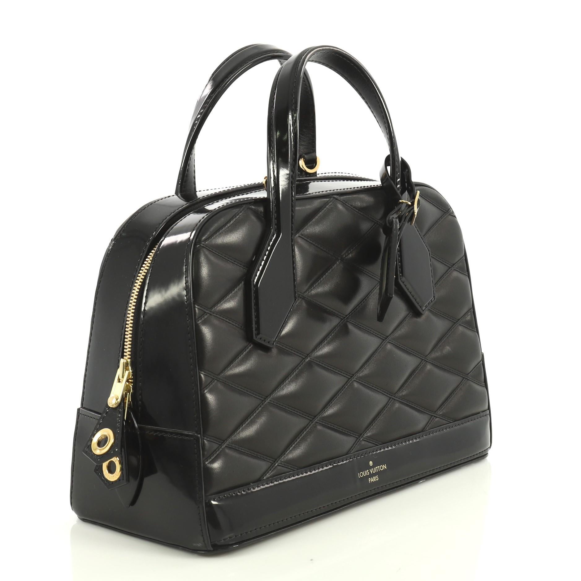 This Louis Vuitton Dora Handbag Malletage Leather PM, crafted from black malletage leather, features dual flat leather handles, protective base studs, and gold-tone hardware. Its zip closure opens to a neutral leather interior with slip pockets.