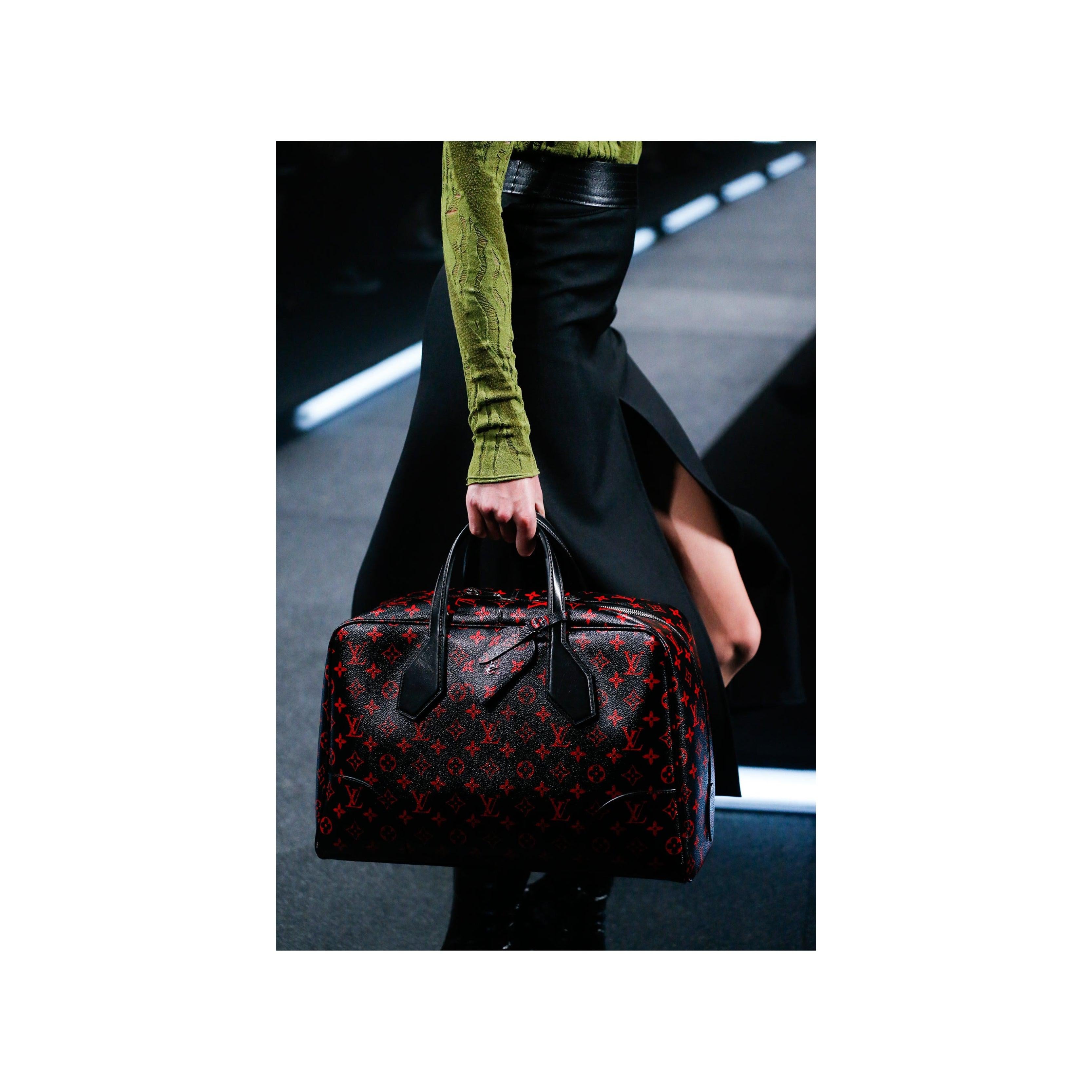 Le sac Dora Soft Infrarouge Canvas MM de Louis Vuitton, issu de la collection printemps/été 2015, est une mise à jour étonnante et avant-gardiste du directeur de la création Nicolas Ghesquiere. Avec sa toile enduite noire brillante et son monogramme