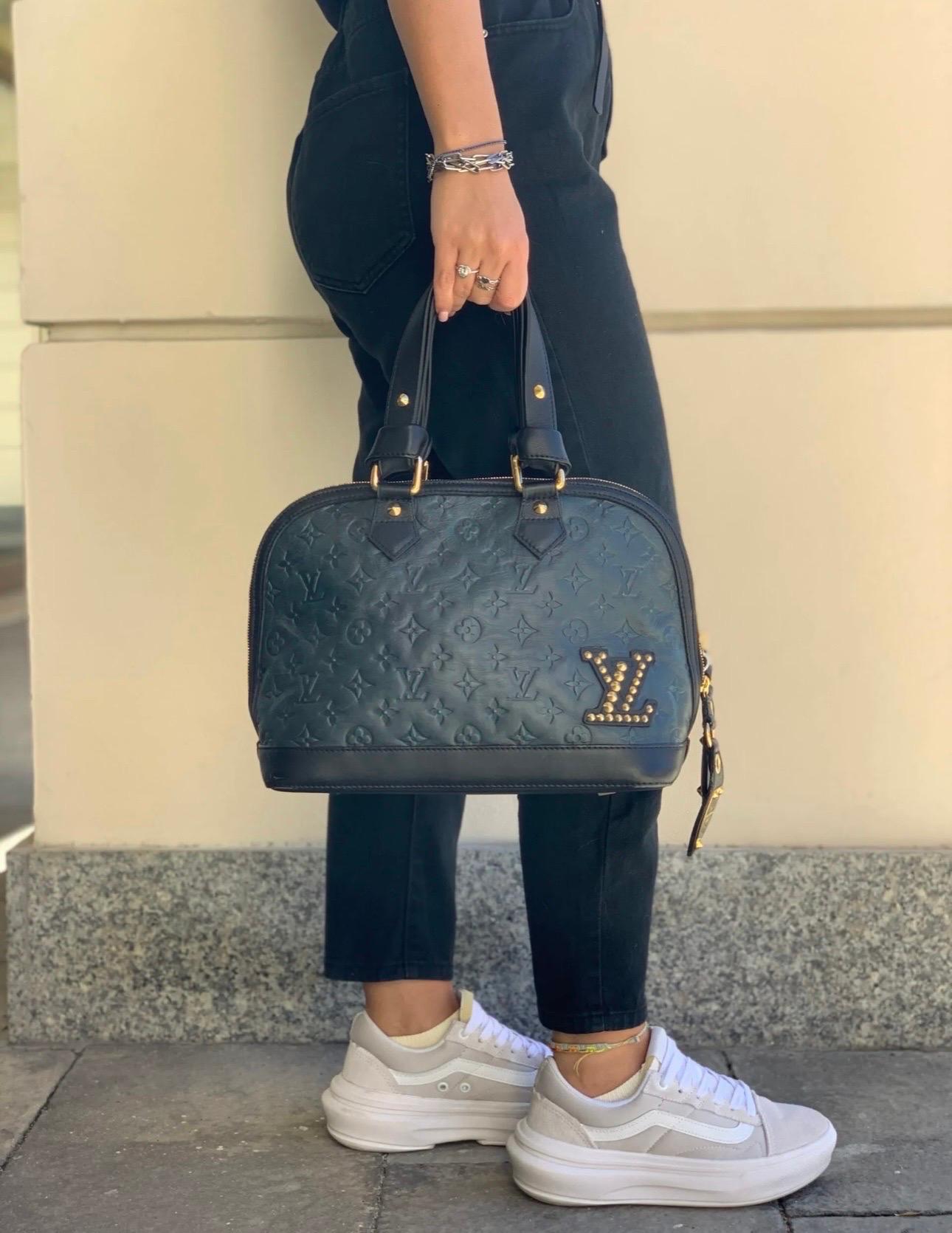 Louis Vuitton bag, Double Jeu Alma model, made of blue empreinte leather and gold hardware. Classic zip closure. Equipped with double leather handle. Equipped with an additional internal pochette made of lurex fabric, and equipped with a double