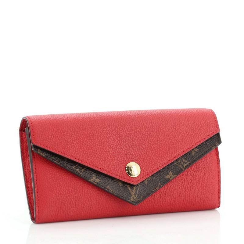 This Louis Vuitton Double V Wallet Leather with Monogram Canvas, crafted in red leather and brown monogram coated canvas, features two V-shaped flaps and gold-tone hardware. Its magnetic snap button closure opens to a red leather interior with