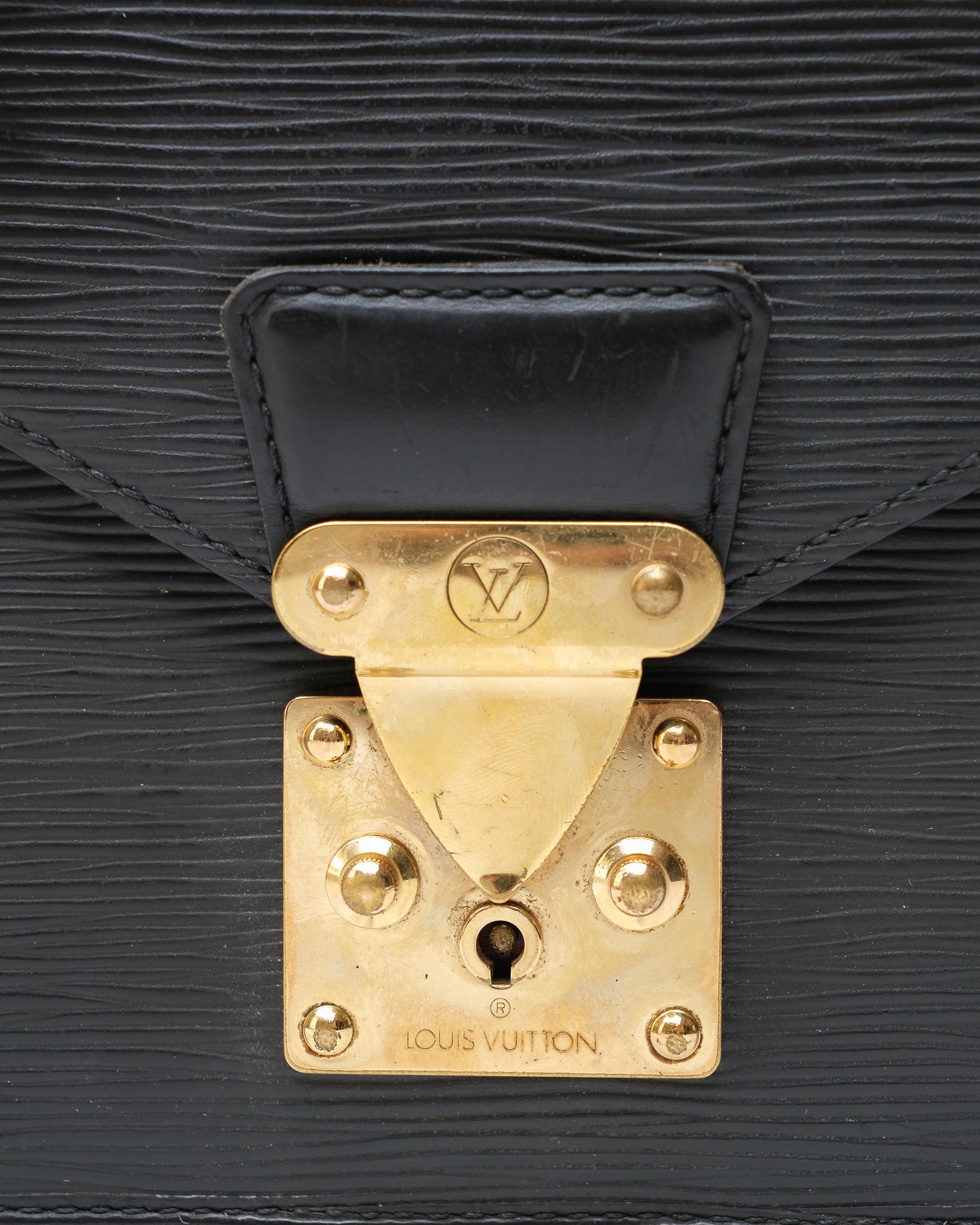 Clutch firmata Louis Vuitton, modello Dragonne, misura PM, realizzata in pelle epi nera con hardware dorati. Dotata di una chiusura ad incastro, internamente rivestita in pelle tono su tono, capiente per l’essenziale. Munita di polsino non