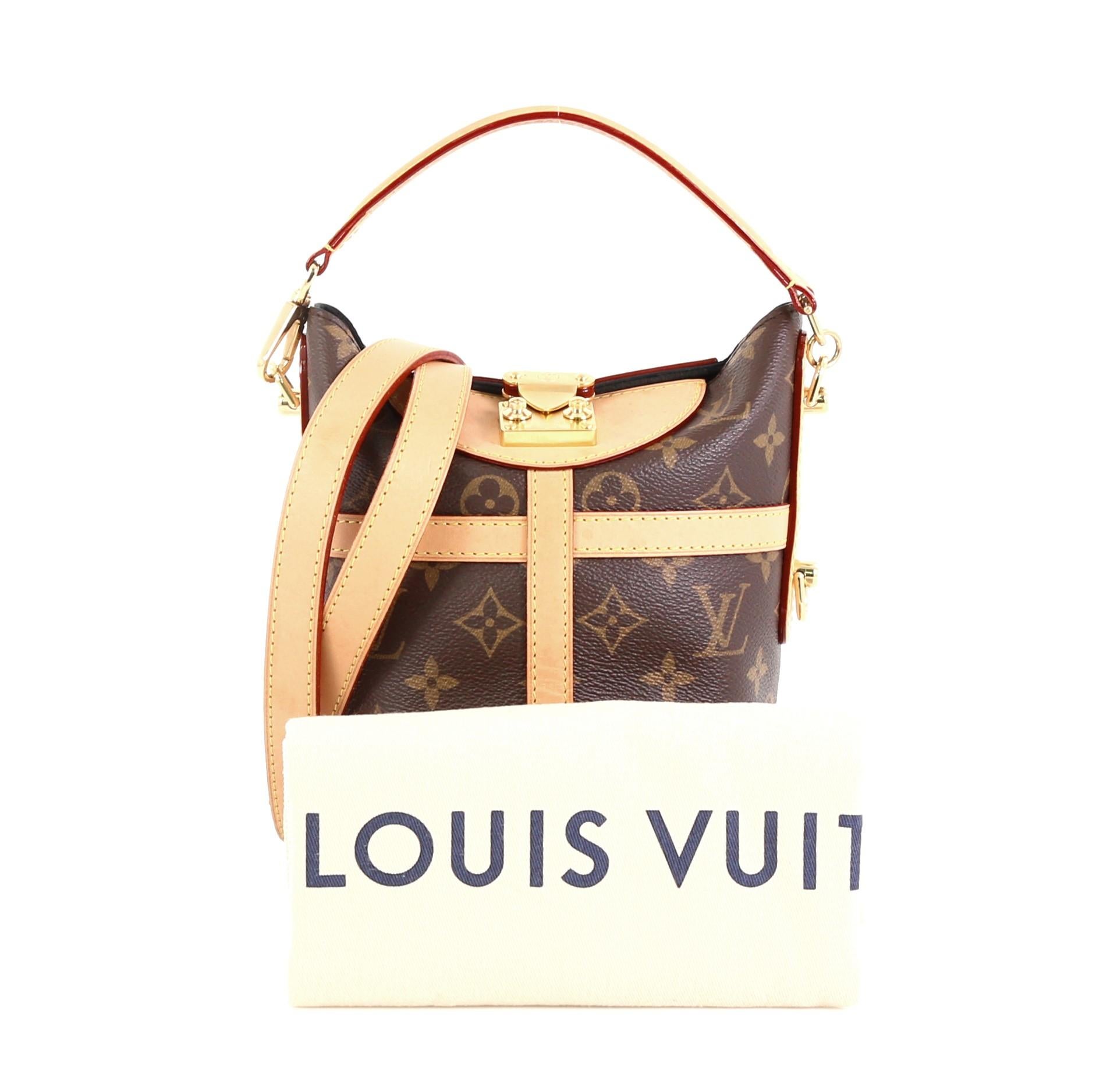 This Louis Vuitton Duffle Handbag Monogram Canvas, crafted from brown monogram coated canvas, features a detachable top handle, detachable shoulder strap, and gold-tone hardware. Its s-lock closure opens to a black microfiber interior with slip