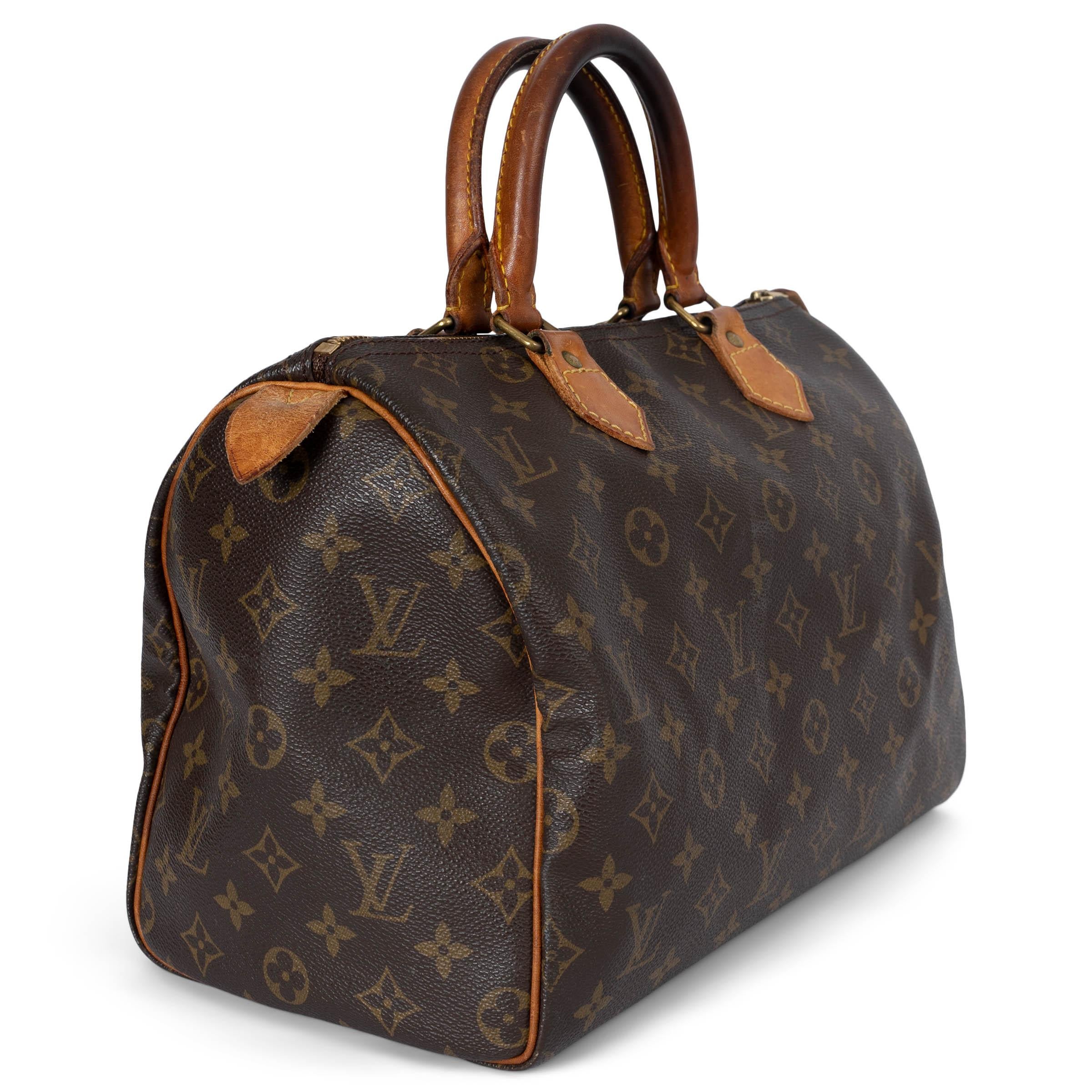 This 100% authentic Louis Vuitton Speedy 30 bag is crafted from ebony and olive Monogram canvas, featuring elegant natural Vachetta leather trims. It closes securely with a zipper and padlock on top, ensuring your belongings are safe. Unlined for a