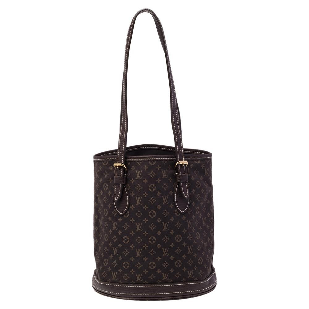 The bucket bag is a classy design from the house of Louis Vuitton. Exuding the label's rich craftsmanship and creativity, the bag is made of Mini Lin canvas and leather into a stylish design. The bag opens to a fabric-lined interior, spacious enough