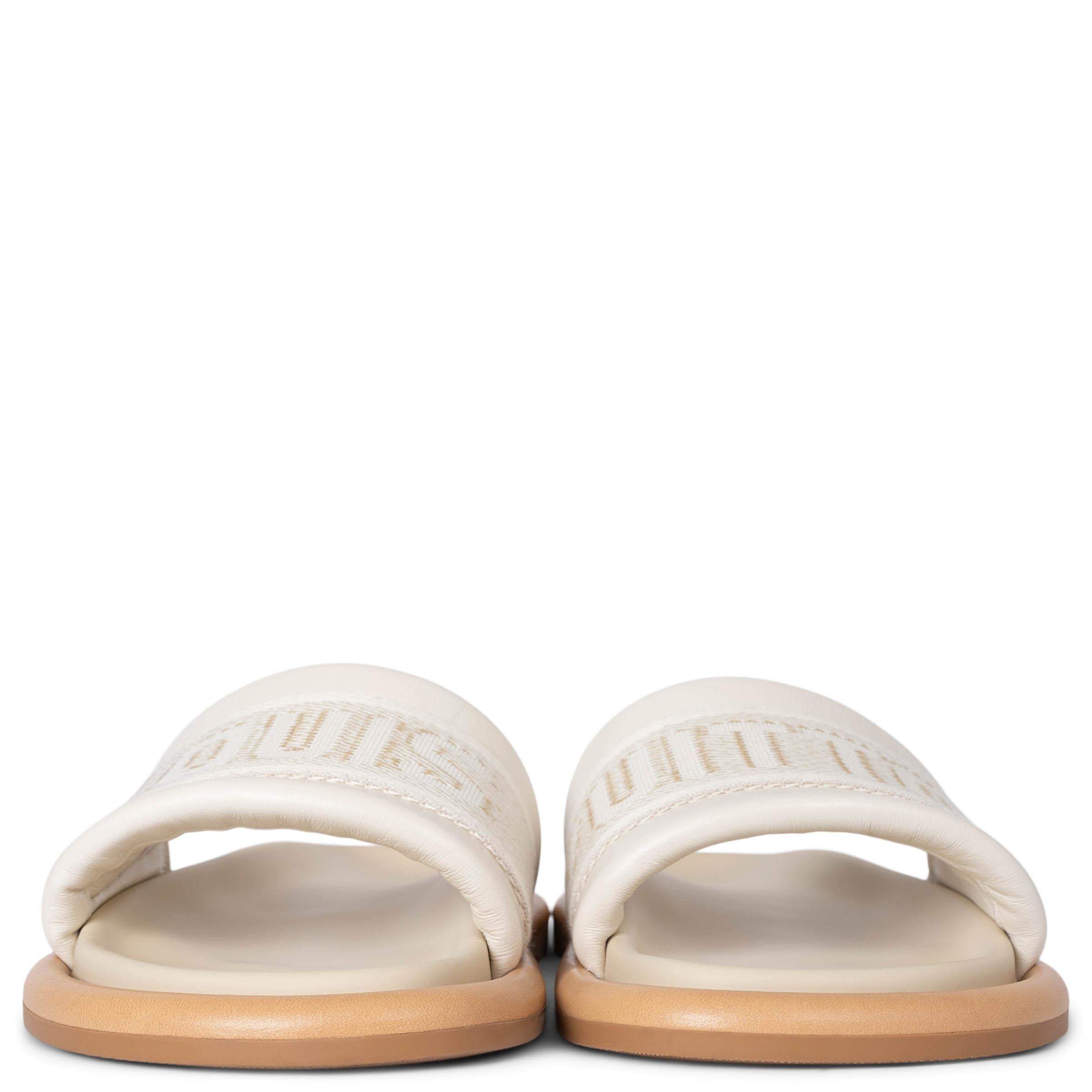 Estas sandalias LV Bliss Comfort Mules 100% auténticas de Louis Vuitton están fabricadas con materiales de primera calidad y cuentan con anchas tiras delanteras de lona en color crudo, estampadas con una firma Louis Vuitton sobredimensionada para un