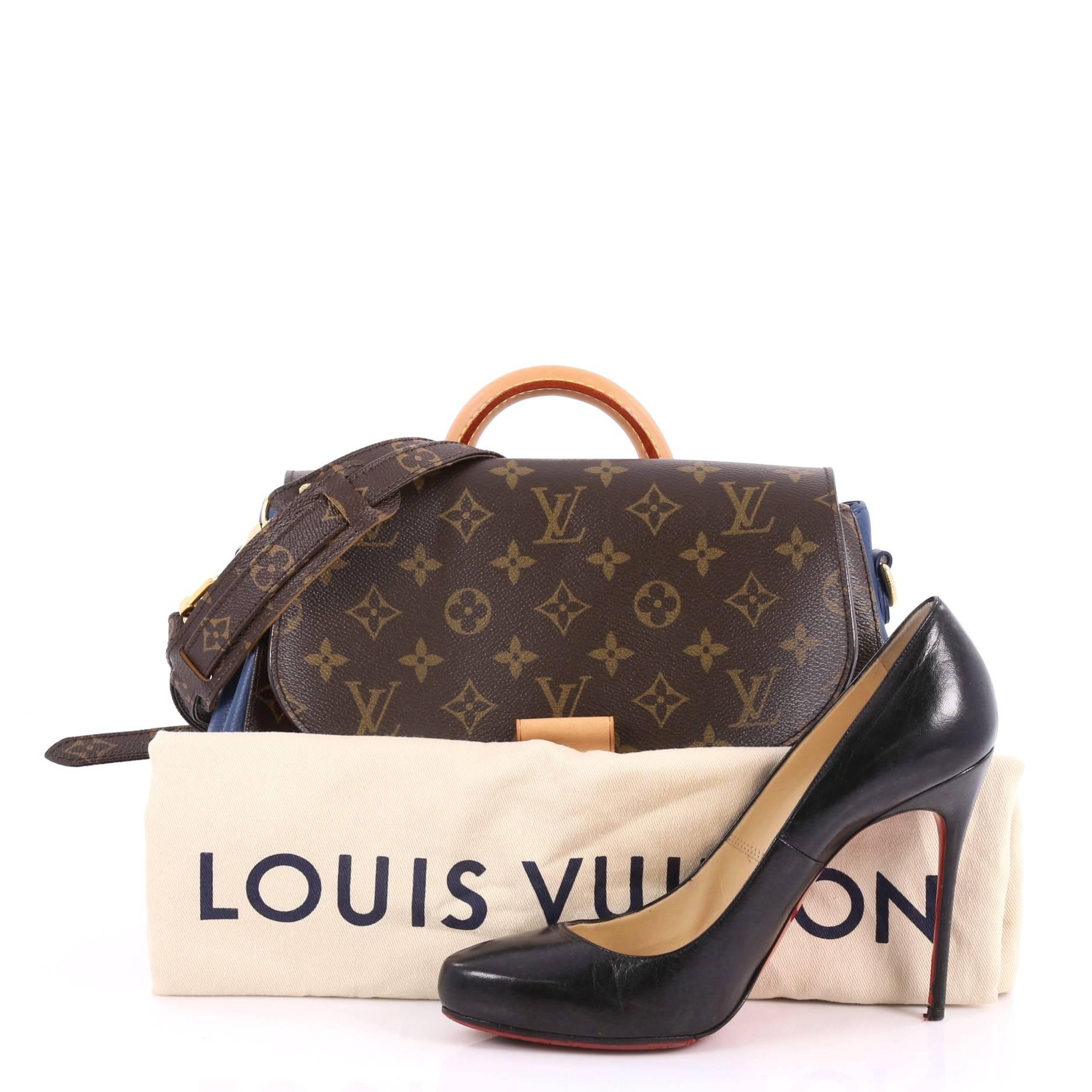 This authentic Louis Vuitton Eden Handbag Monogram Canvas MM is a tribute to the brand's classic and timeless design with a modern twist. Crafted in its iconic monogram coated canvas with blue calfskin side panels, this heritage-inspired bag