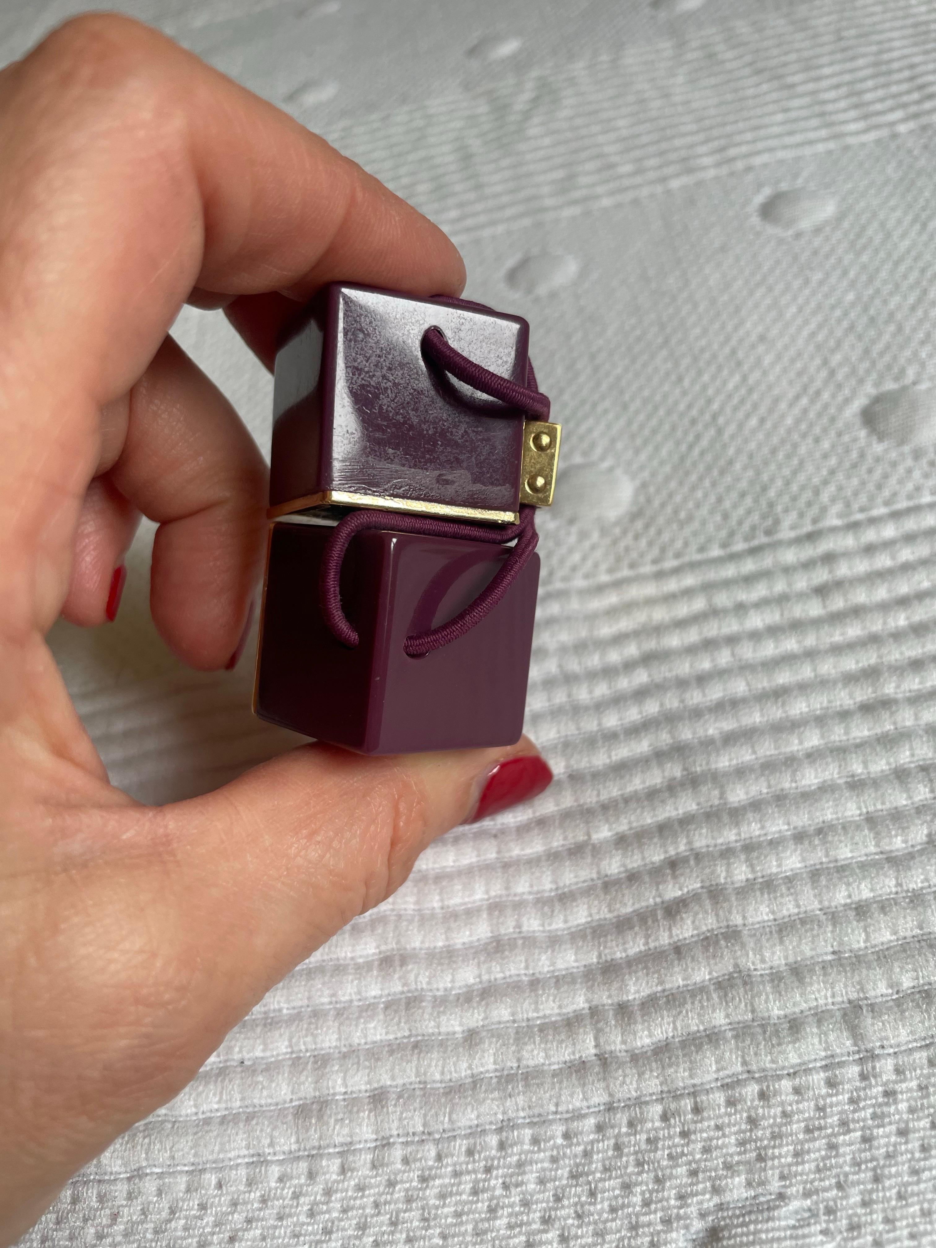 Elastico Louis Vuitton. Consiste in 2 grandi cubi con il logo del marchio. L'elastico è in ottime condizioni. Solo qualche graffio e un lato leggermente usurato. Discreto.