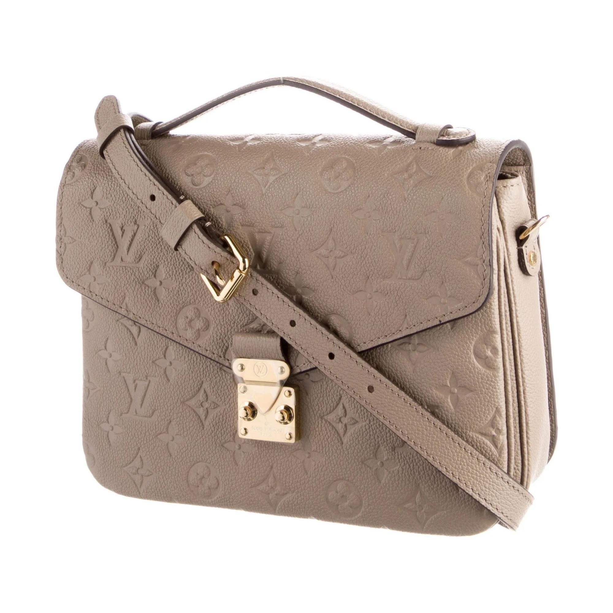 This shoulder bag is constructed of Louis Vuitton monogram-embossed leather in tourterelle grey (light taupe). Louis's empreinte leather is a supple grained cowhide with monogram embossing. The bag features a leather top handle, an optional