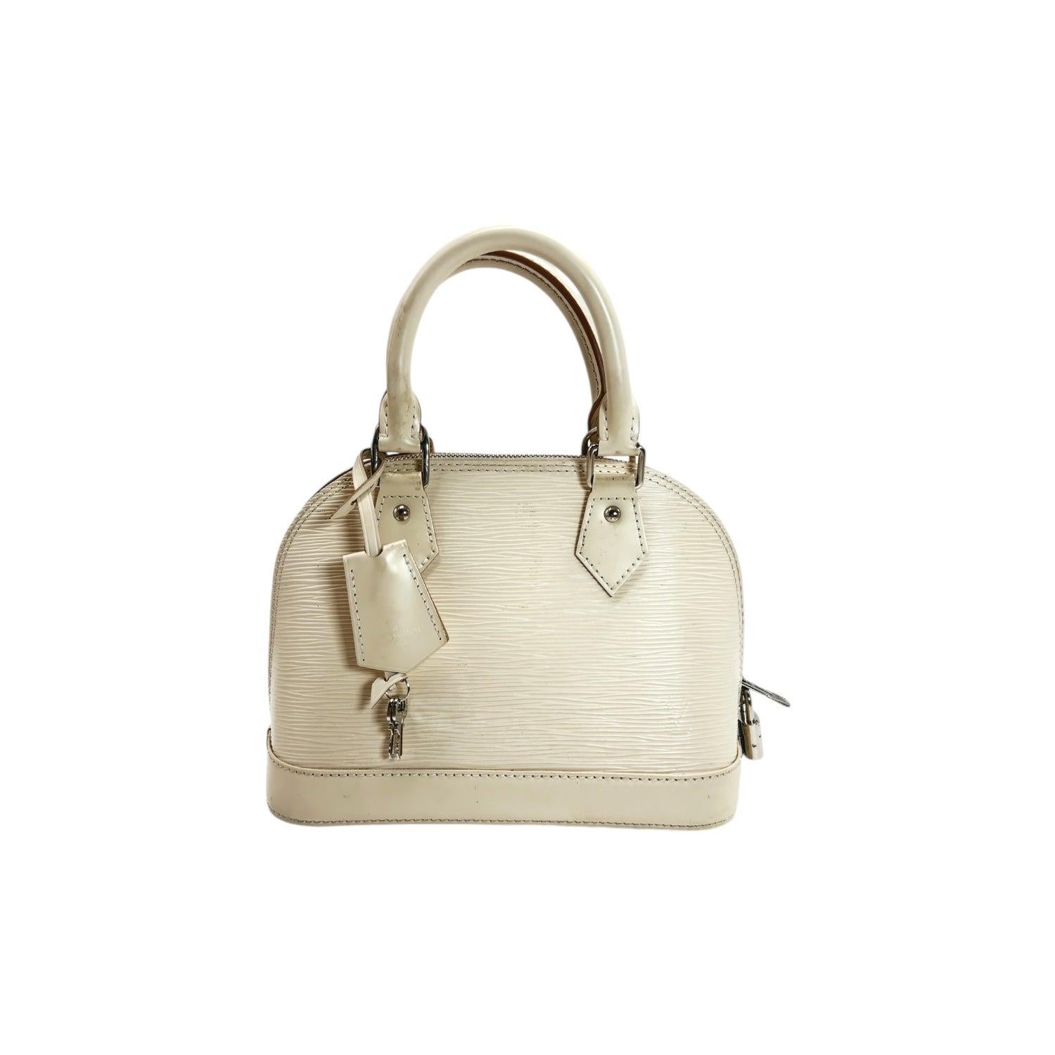 Expertly crafted with durable Epi Leather, the Louis Vuitton Epi Jacquard Alma BB Quartz Handbag is a luxurious addition to any wardrobe. This designer bag features rolled leather top handles, a double zip closure at the top, and a microfiber
