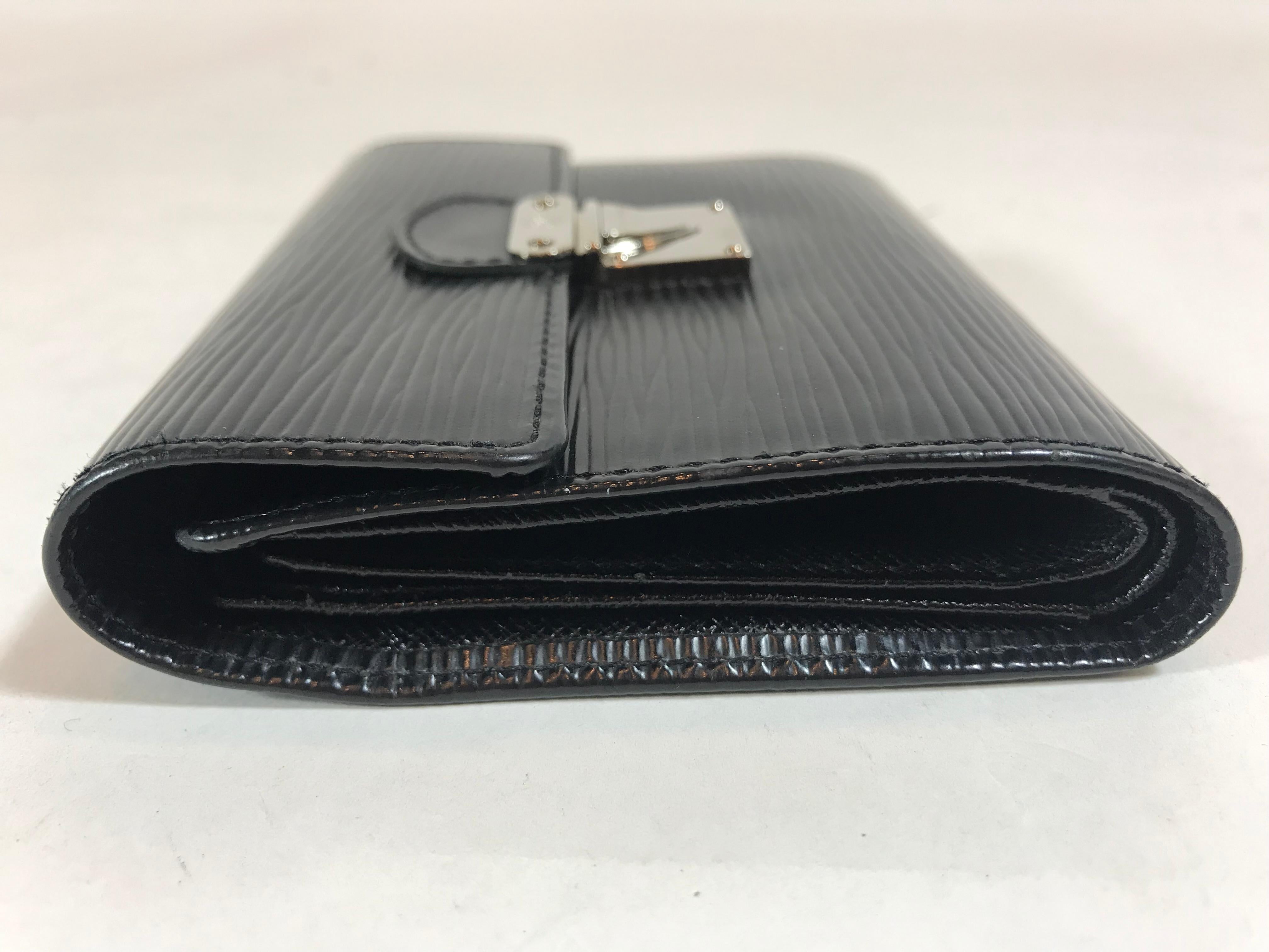 Black Epi leather. Silver-tone hardware. Push-lock closure at front. Exterior zip pocket at back. Tonal leather interior. Single bill compartment and nine card slots featuring clear ID slot.