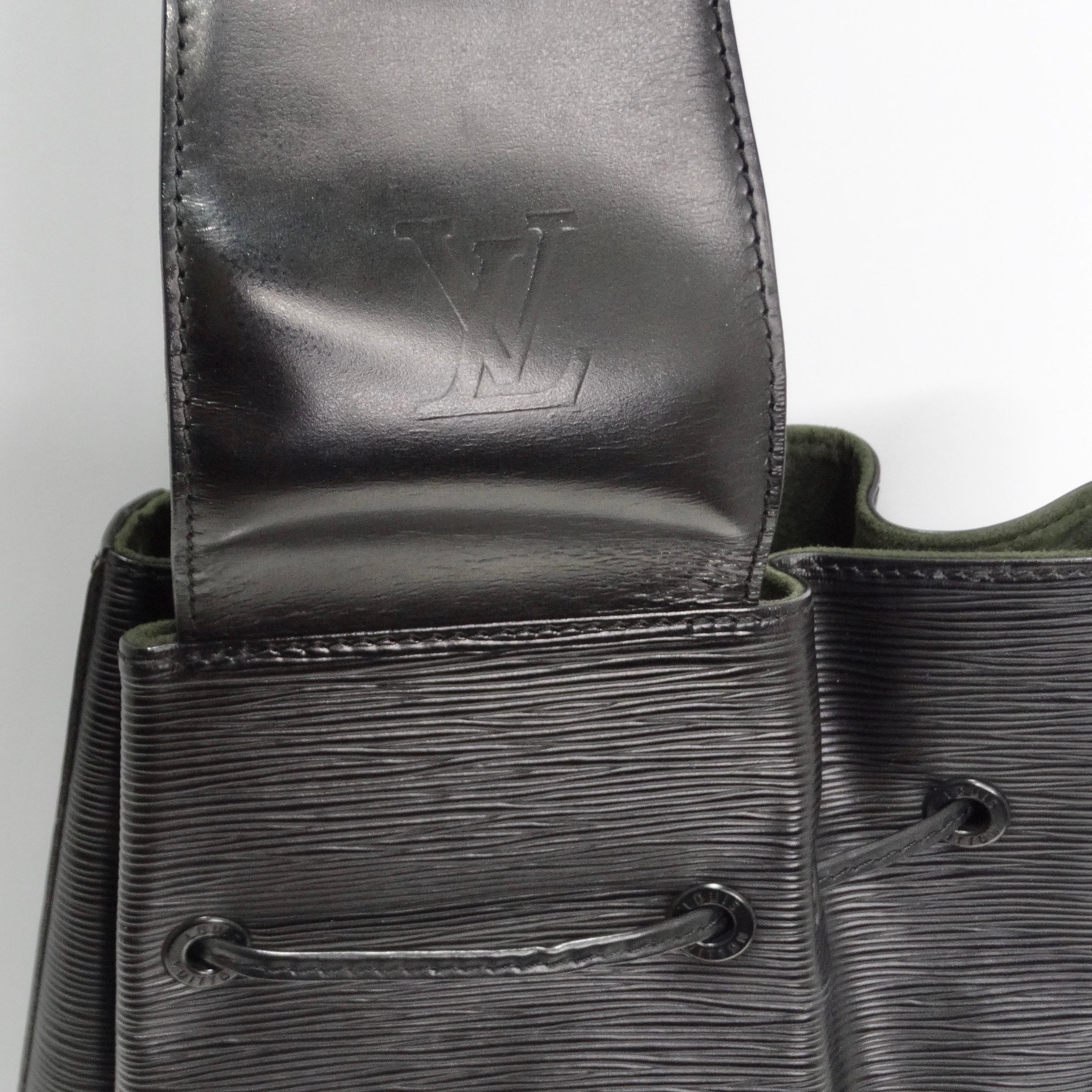 Voici le sac à cordon en cuir épi Louis Vuitton en noir, un sac à bandoulière vintage élégant et polyvalent fabriqué à partir du cuir épi texturé signature de Louis Vuitton. Ce sac emblématique est doté d'une longue bandoulière en cuir lisse qui
