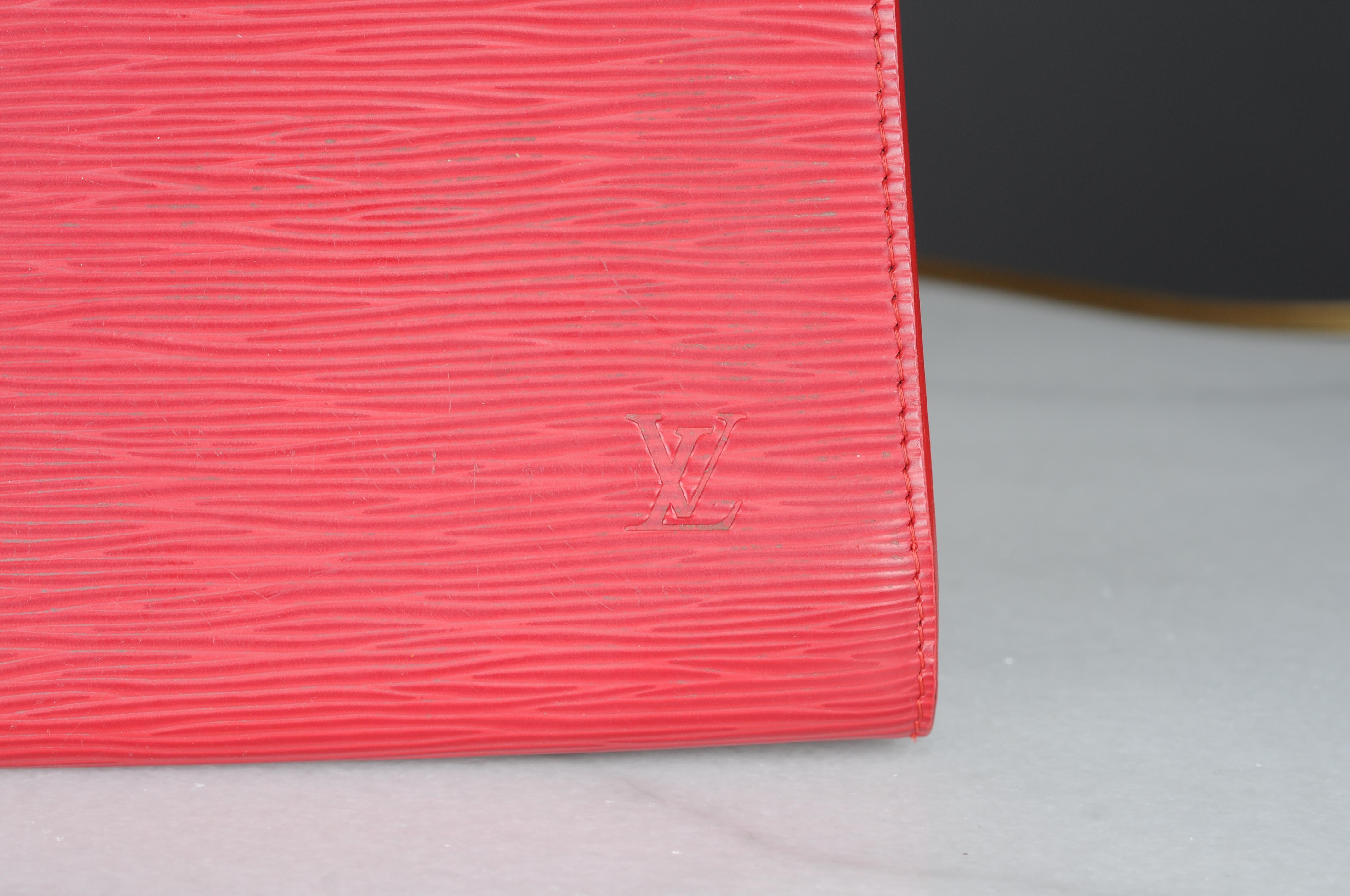 Le sac à main Pochette Accessories est réinterprété dans le cuir Epi caractéristique de Louis Vuitton. Le design emblématique présente une silhouette élégante et horizontale qui évoque subtilement le style vintage. Une lanière de cuir amovible