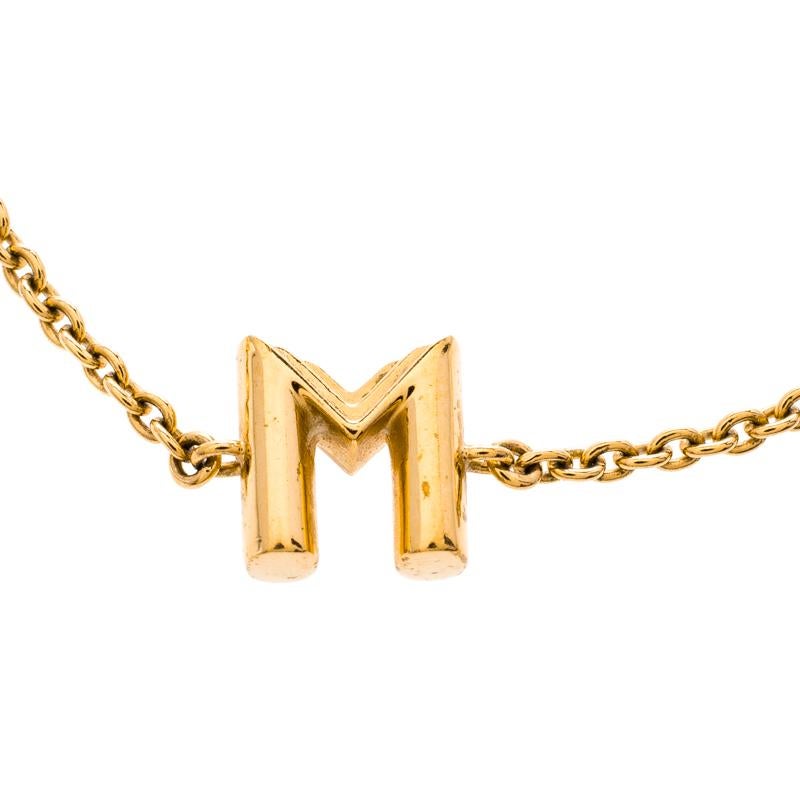 In this stunning piece, the signature V of the Essential collection by Louis Vuitton gets a personalised twist with the letter M instead of the V. The bracelet is made in gold-tone metal and a slim chain holds the letter M, an oval code tag and a