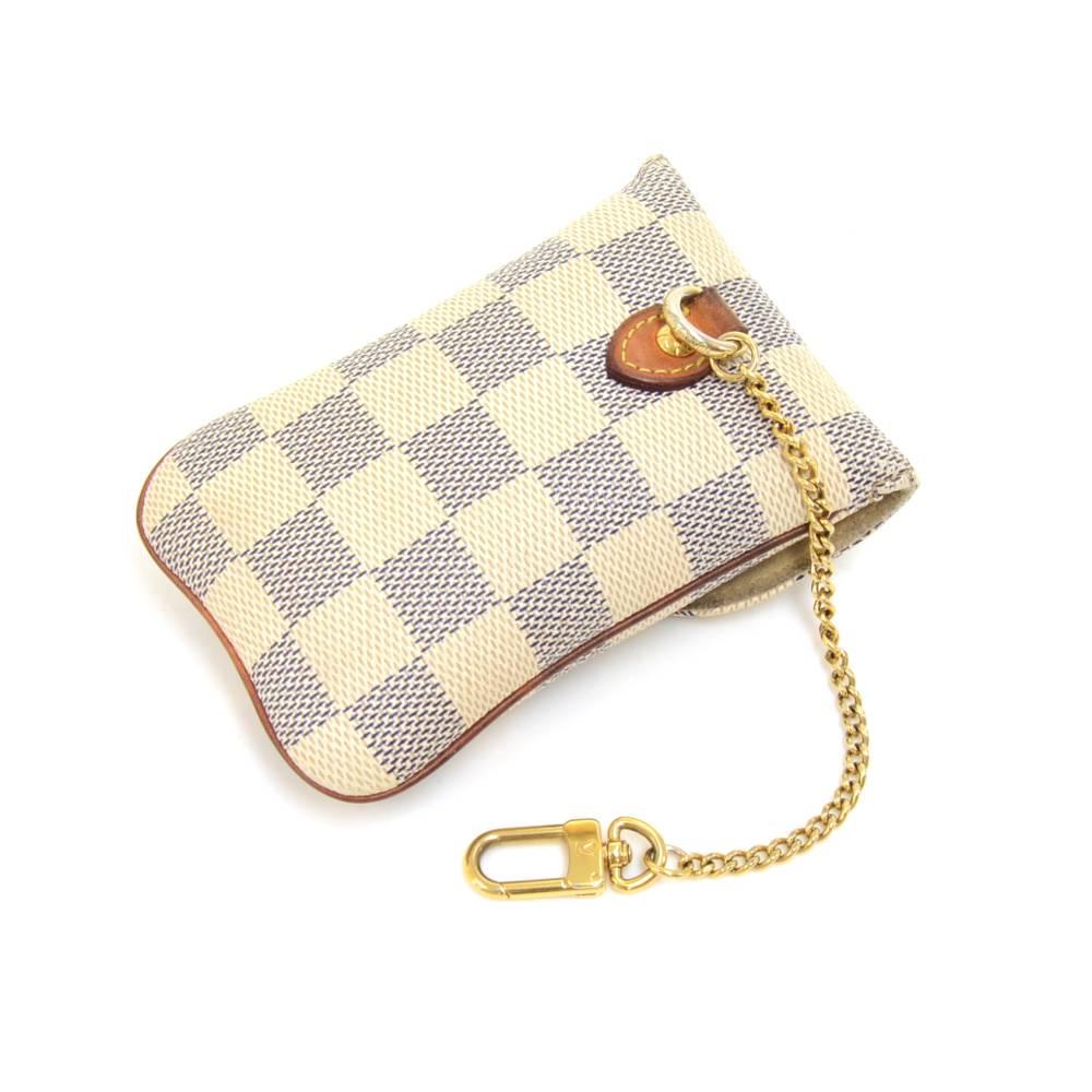 This is Louis Vuitton Etui case in white damier canvas. It can be used for carrying your phone, keys, jewelry, or other small accessories. Comes with a chain and clasp to attach to your bags. SKU: LO706

Made in: France
Serial Number: SN8141
Size: