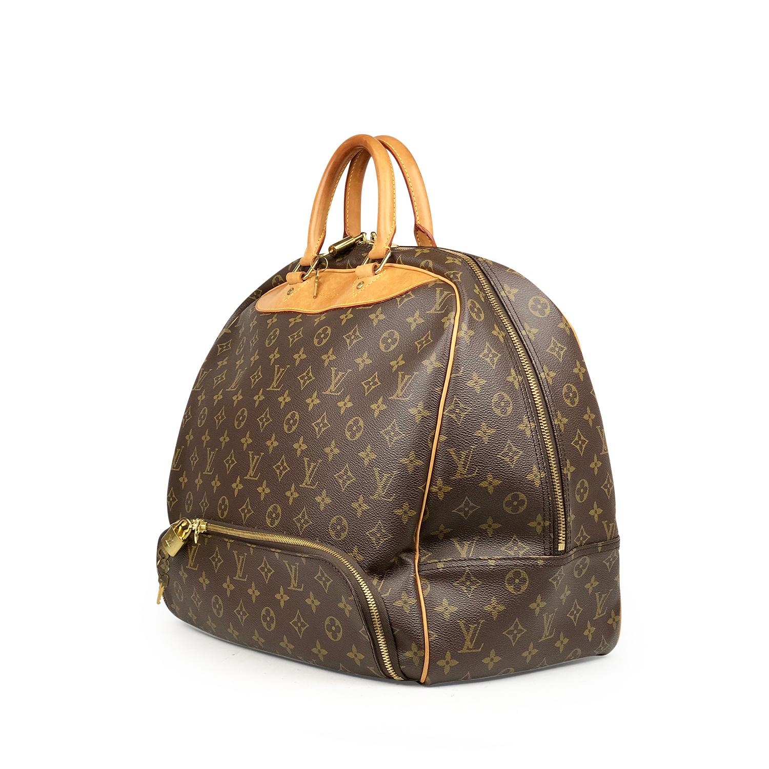 Moka and olive-brown monogram coated canvas Louis Vuitton Evasion bag with

- Brass hardware
- Caramel vachetta leather trim
- Dual rolled top handles
- Beige coated canvas lining
- Single slip pocket at interior and two-way zip closure at