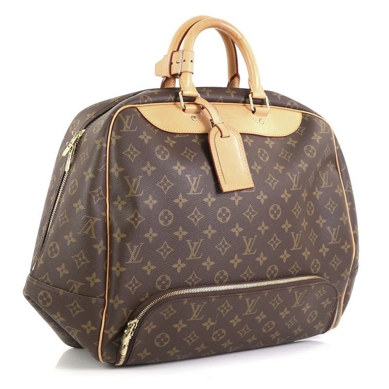 This Louis Vuitton Evasion Travel Bag Monogram Canvas MM, crafted in brown monogram coated canvas, features dual rolled leather handles, front bottom zip compartment, and gold-tone hardware. Its two-way zip closure opens to a neutral canvas interior