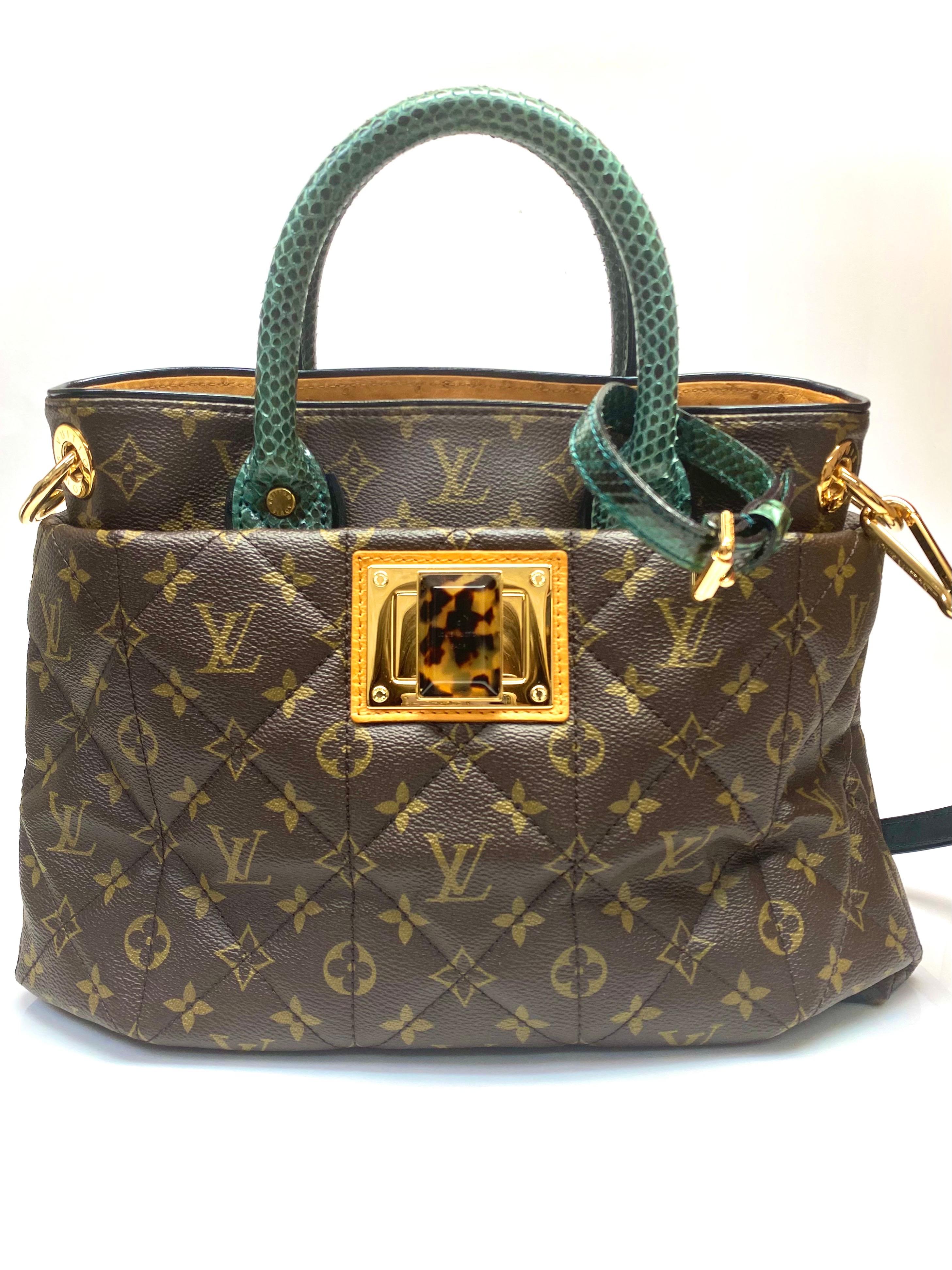 This exotic Louis Vuitton MM features a quilted monogram canvas body with ostrich leather trim, rolled python leather handles, a detachable flat leather strap, an open top with a gold-tone and tortoise shell lock closure, and interior zip and slip