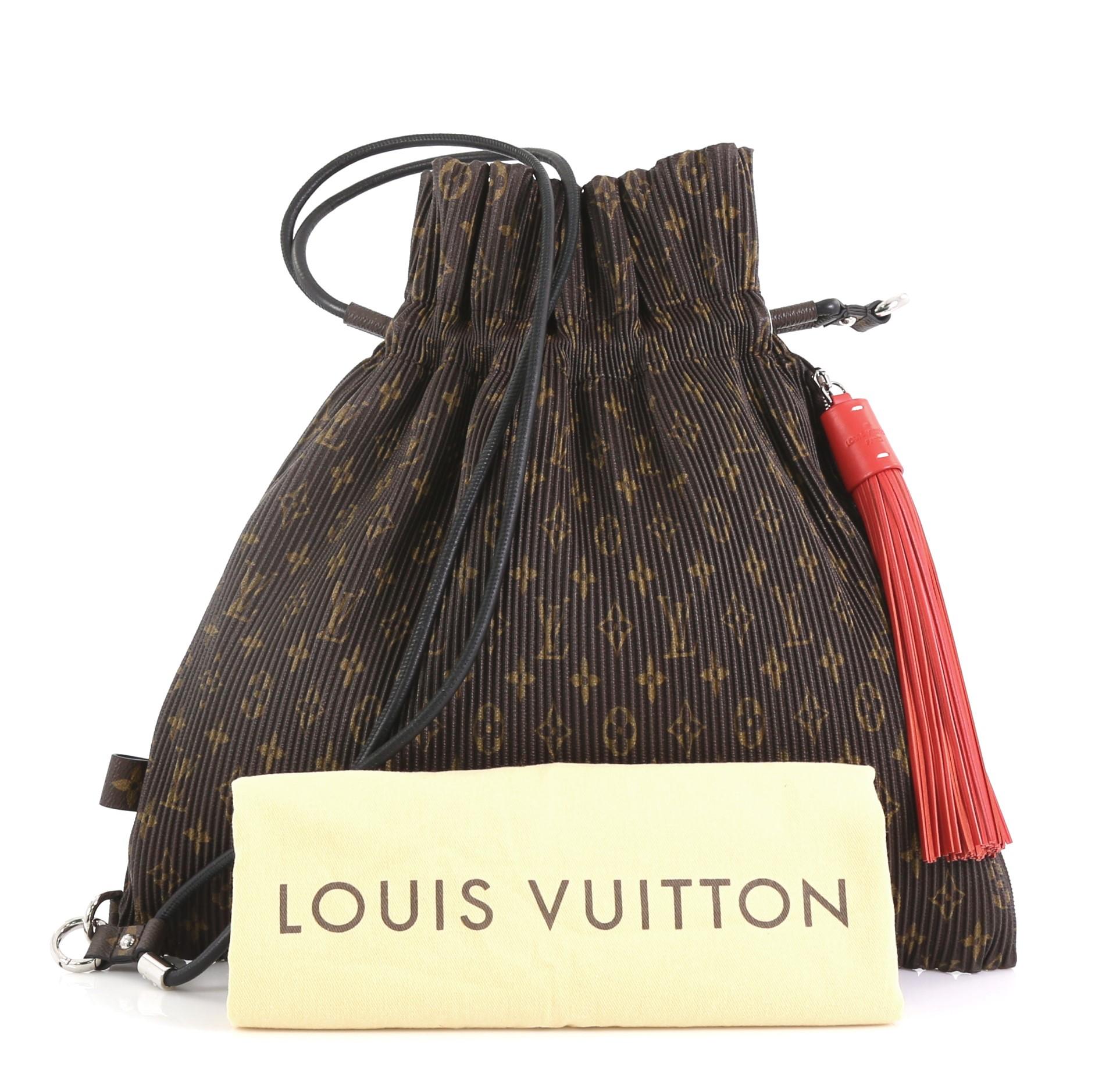 This Louis Vuitton Explorer Shoulder Bag Pleated Monogram Canvas MM, crafted in brown pleated monogram canvas, features a smooth leather shoulder strap, exterior side zip pocket with tassel charm, and silver-tone hardware. Its drawstring closure