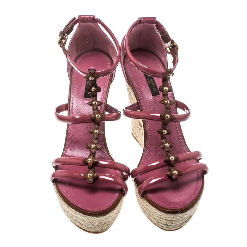Every woman knows that wedges, no matter how high, are pretty easy to walk in. These Louis Vuitton ones are the same, but with more fun and style. They've been designed with monogram flowers on the strappy leather layout, buckle ankle fastenings,