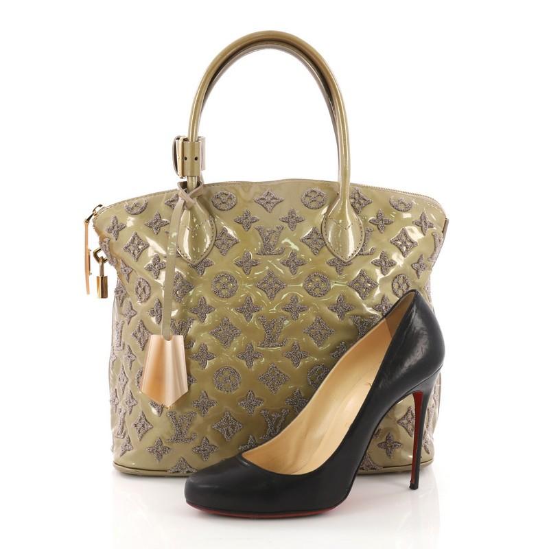 This Louis Vuitton Fascination Lockit Handbag Patent Lambskin, crafted in green patent leather embroidered with LV's iconic monogram bouclette design, features dual rolled handles and gold-tone hardware. Its top zip closure opens to a taupe leather