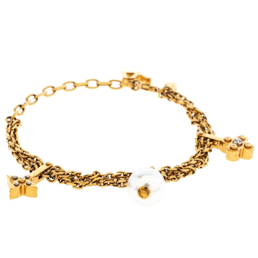Simple yet elegant, this Louis Vuitton bracelet features a gold-tone metal body decorated with signature charms. The charms are eye-catching and they beautifully sway with every movement of your wrist. The bracelet can be fastened using the lobster