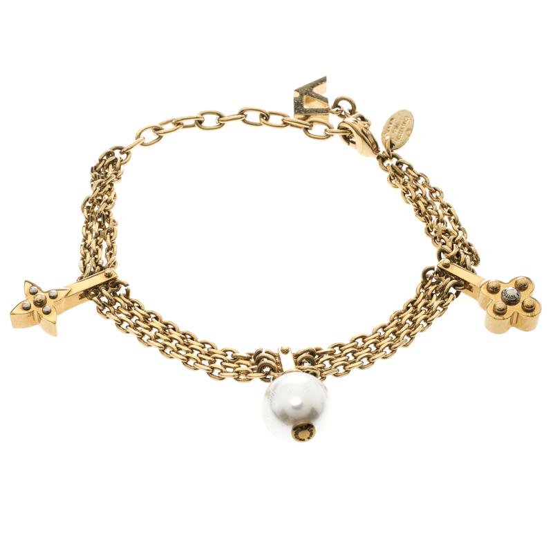 Artfully made from gold-tone metal, this flawless bracelet by Louis Vuitton can be your next prized possession. Featuring multiple chains with gorgeous charms of faux pearls and monogram flowers, the design has been finished with a lobster clasp.