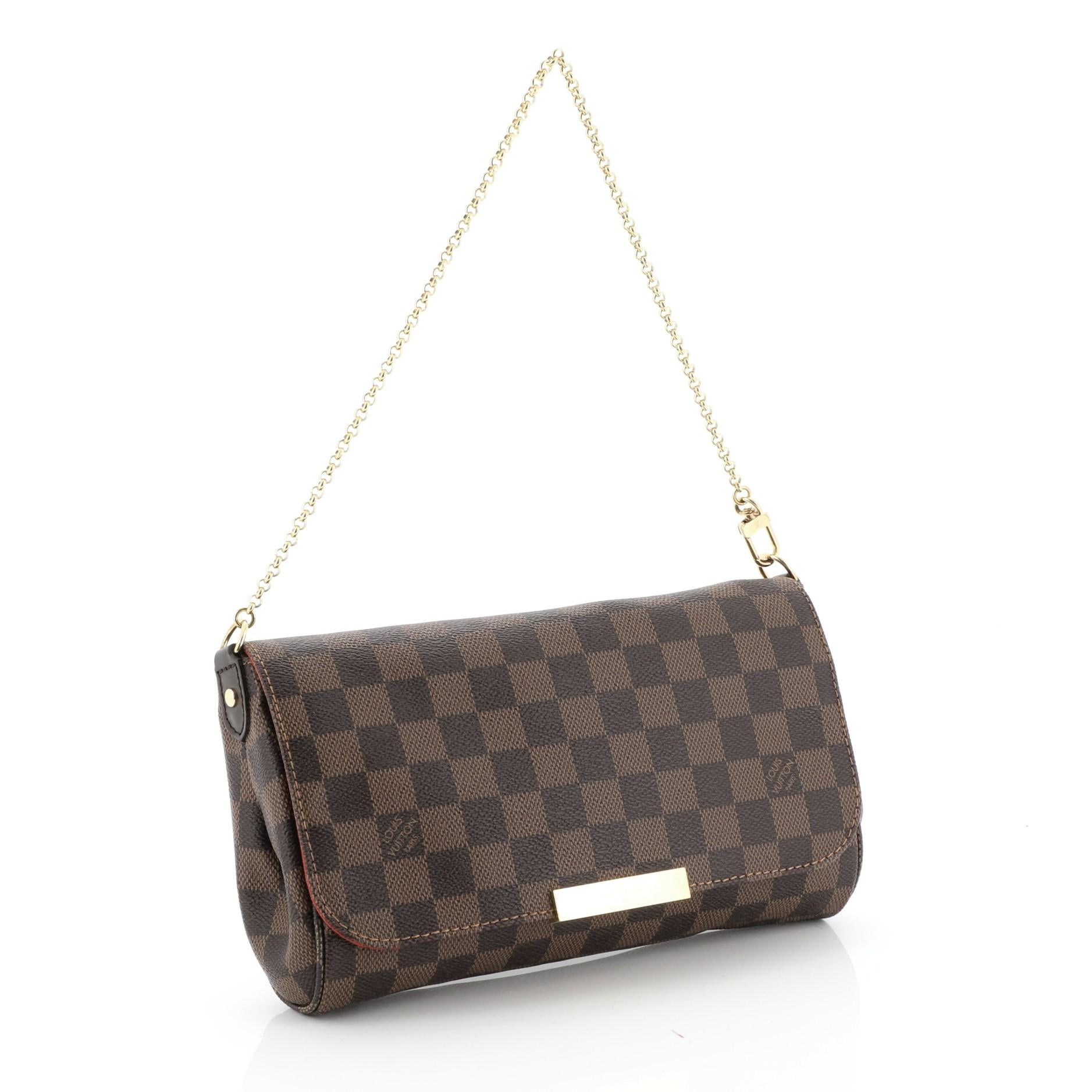 This Louis Vuitton Favorite Handbag Damier MM, crafted in damier ebene coated canvas, features a long leather strap, short chain strap, LV plated logo and gold-tone hardware. Its flap closure opens to a red fabric interior with slip pocket.