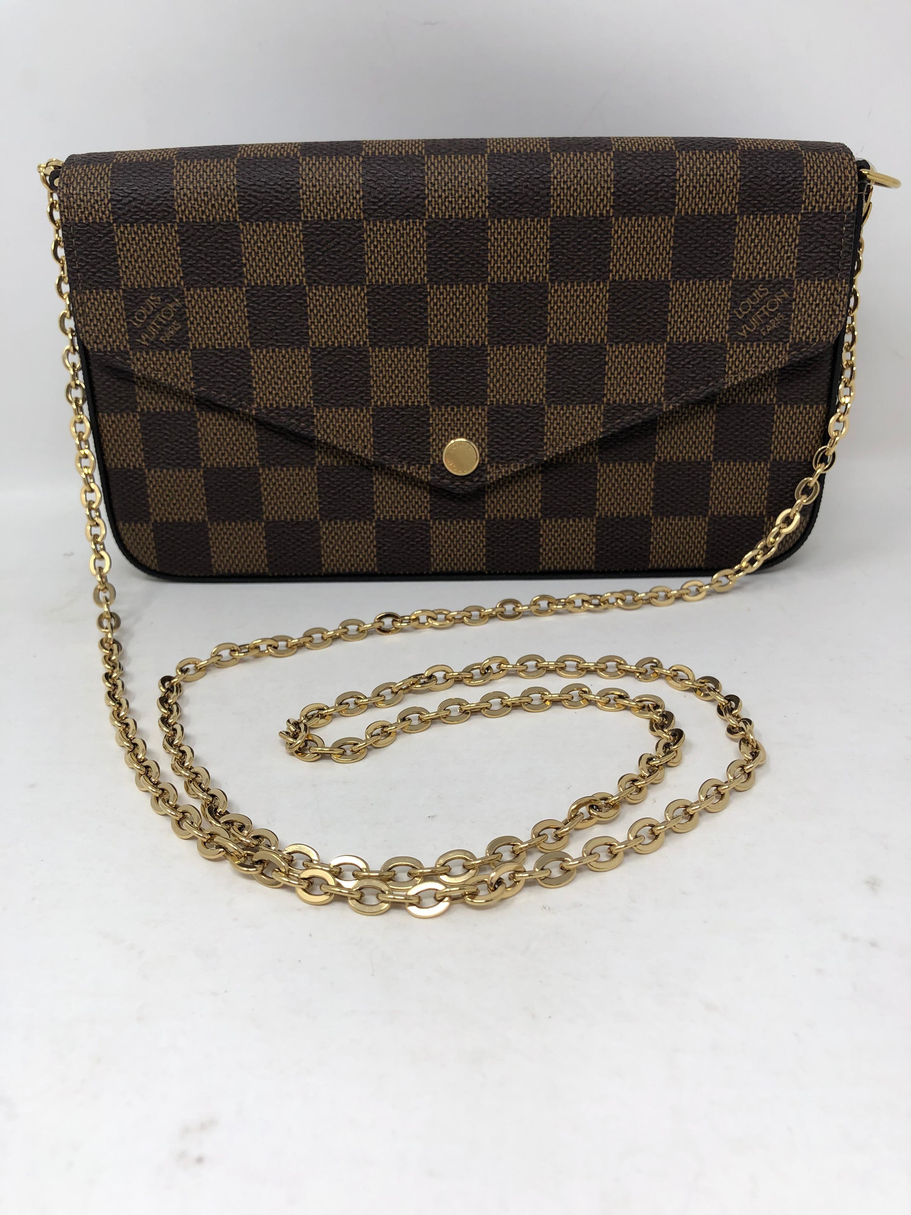 Louis Vuitton Felicie Damier Ebene Crossbody Bag. Bag can be worn as a clutch or with strap. Red interior. Never worn, new condition. Guaranteed authentic. 