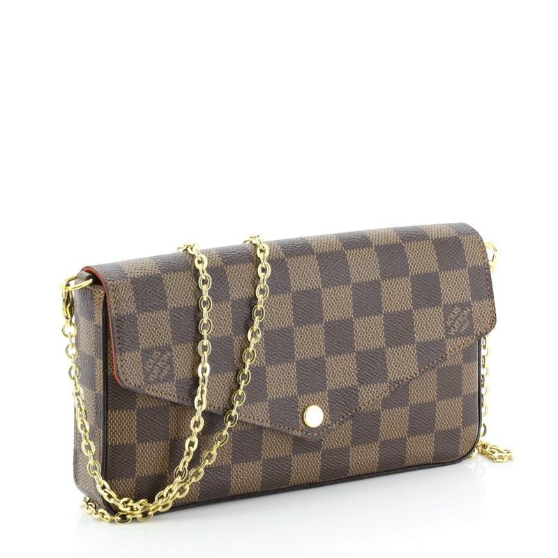 This Louis Vuitton Felicie Pochette Damier, crafted from damier ebene coated canvas, features detachable chain link shoulder strap and gold-tone hardware. Its press stud closure opens to a red fabric interior with slip pocket. Authenticity code