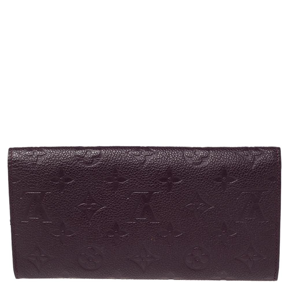 One of the most famous wallets by Louis Vuitton is the Sarah. This one here comes made from Monogram Empreinte leather and the button on the flap opens to an interior with multiple card slots and a zip pocket. Perfect in size, this wallet can easily