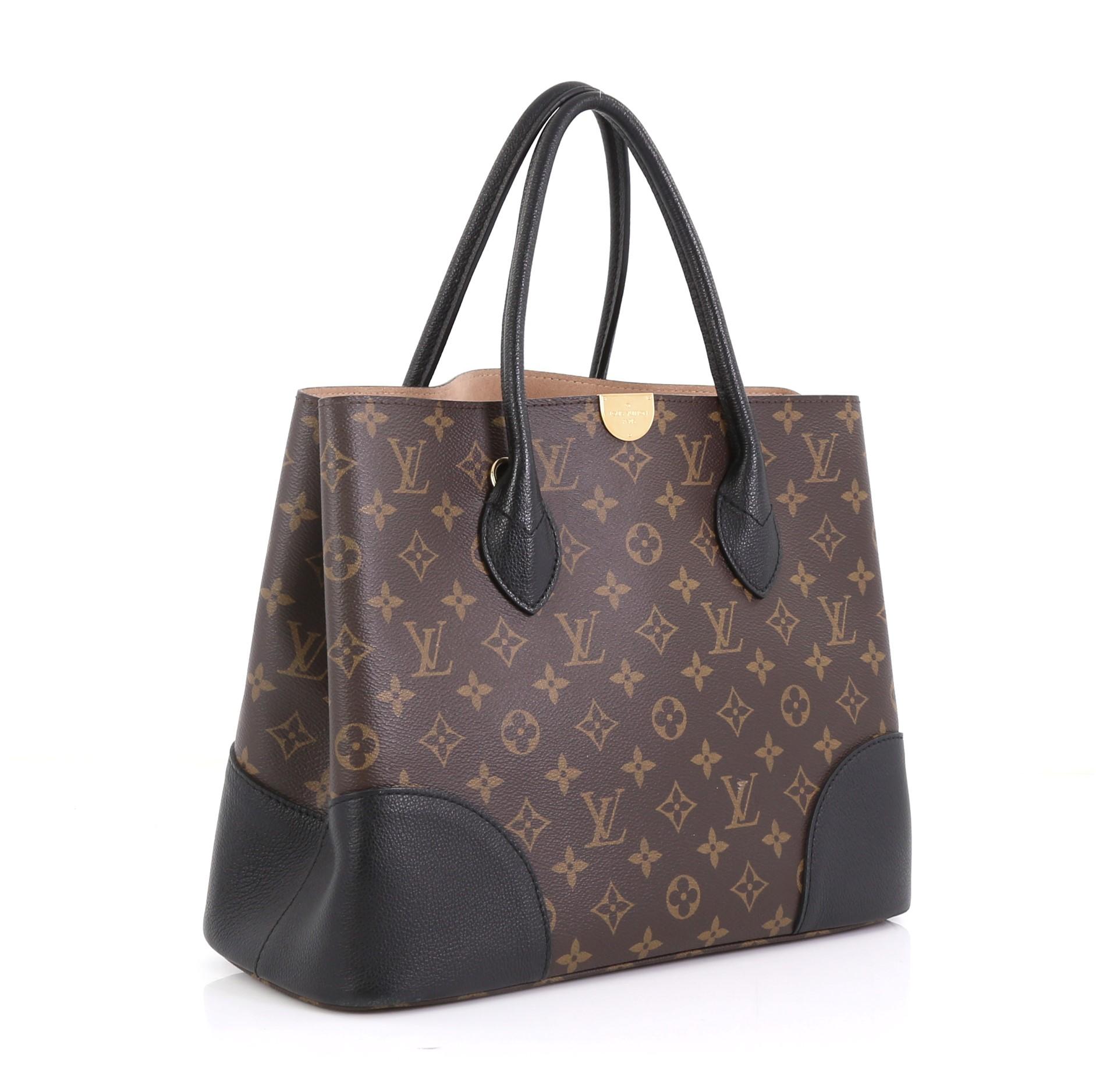 This Louis Vuitton Flandrin Handbag Monogram Canvas, crafted from brown monogram coated canvas and black leather, features dual rolled leather handles and gold-tone hardware. It opens to a nude microfiber interior with a center zip compartment.