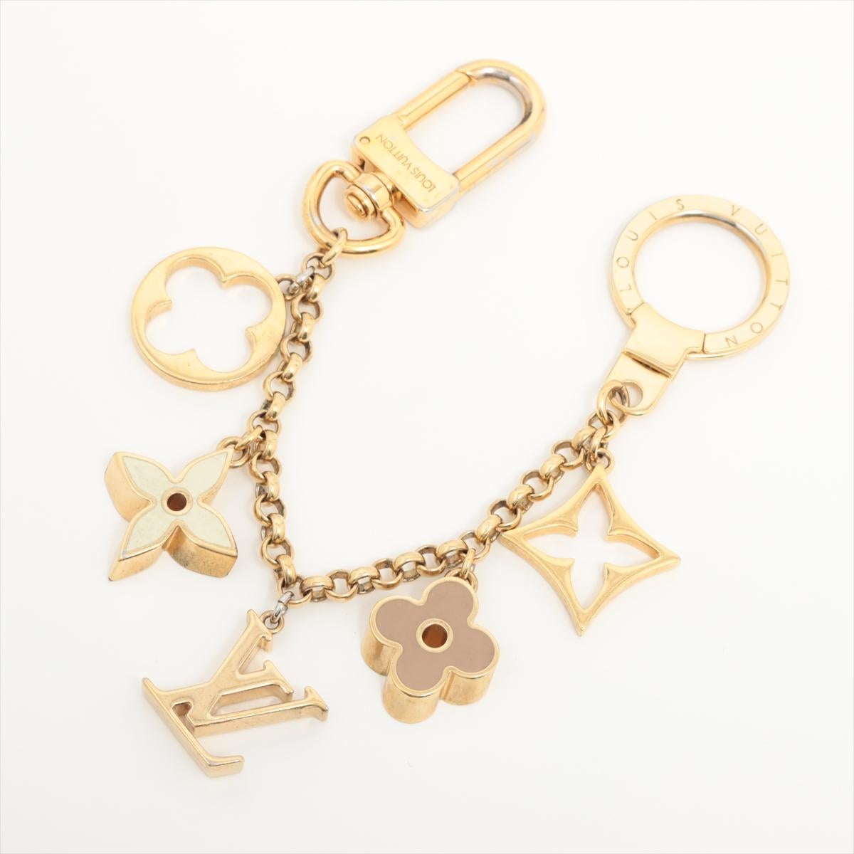 The Louis Vuitton Fleur De Monogram Bag Charm is a stunning accessory that adds a touch of elegance and luxury to your handbag or keys. The intricate details of the flower petals and the gold-tone hardware showcase the exquisite craftsmanship and