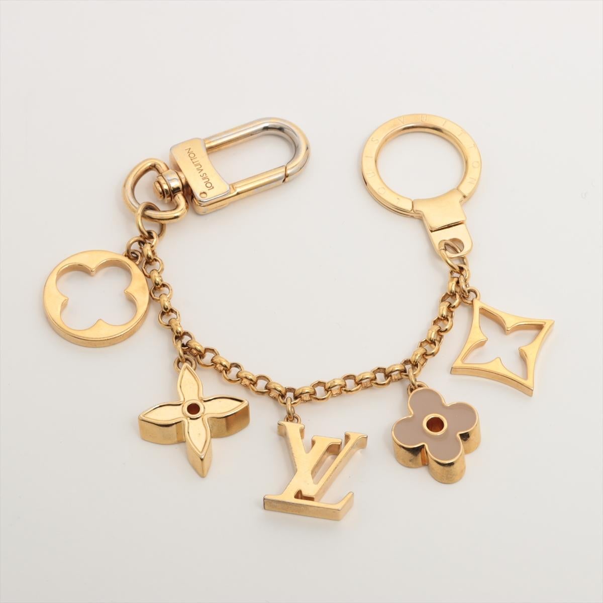 Der Louis Vuitton Fleur De Monogram Bag Charm ist ein umwerfendes Accessoire, das Ihrer Handtasche oder Ihrem Schlüssel einen Hauch von Eleganz und Luxus verleiht. Die filigranen Details der Blütenblätter und die goldfarbenen Beschläge zeugen von