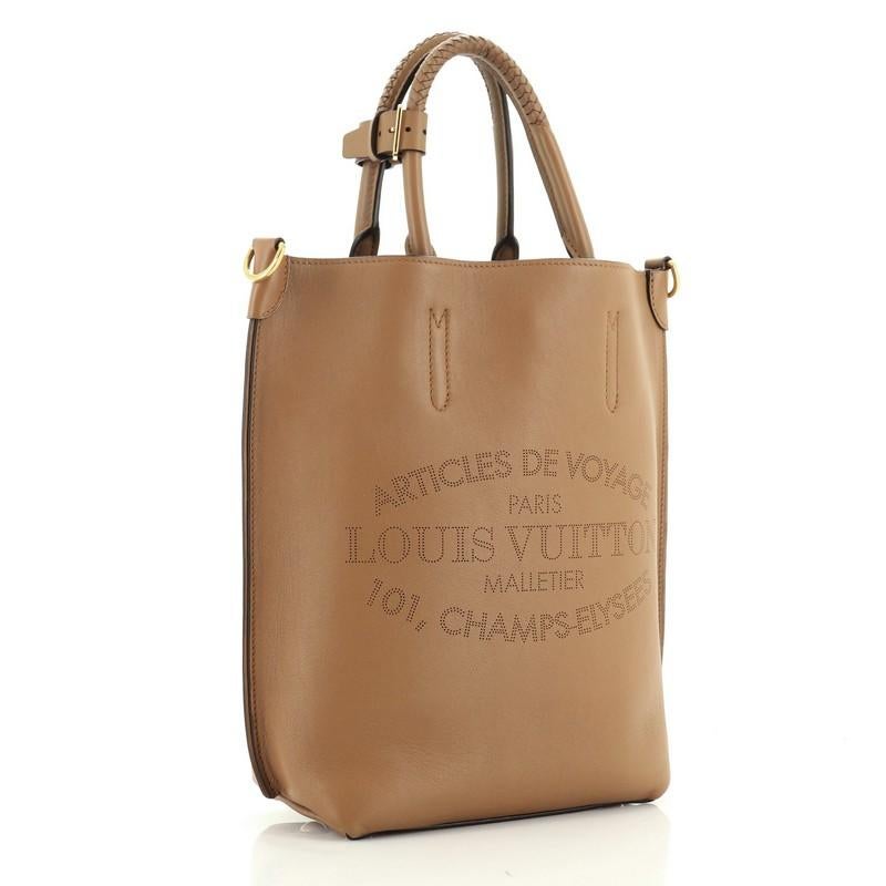 This Louis Vuitton Flore Handbag Leather MM, crafted from brown leather, features braided leather handles, heritage signature Articles de Voyage pinpoint perforated design and gold-tone hardware. Its claw clasp closure opens to a brown microfiber