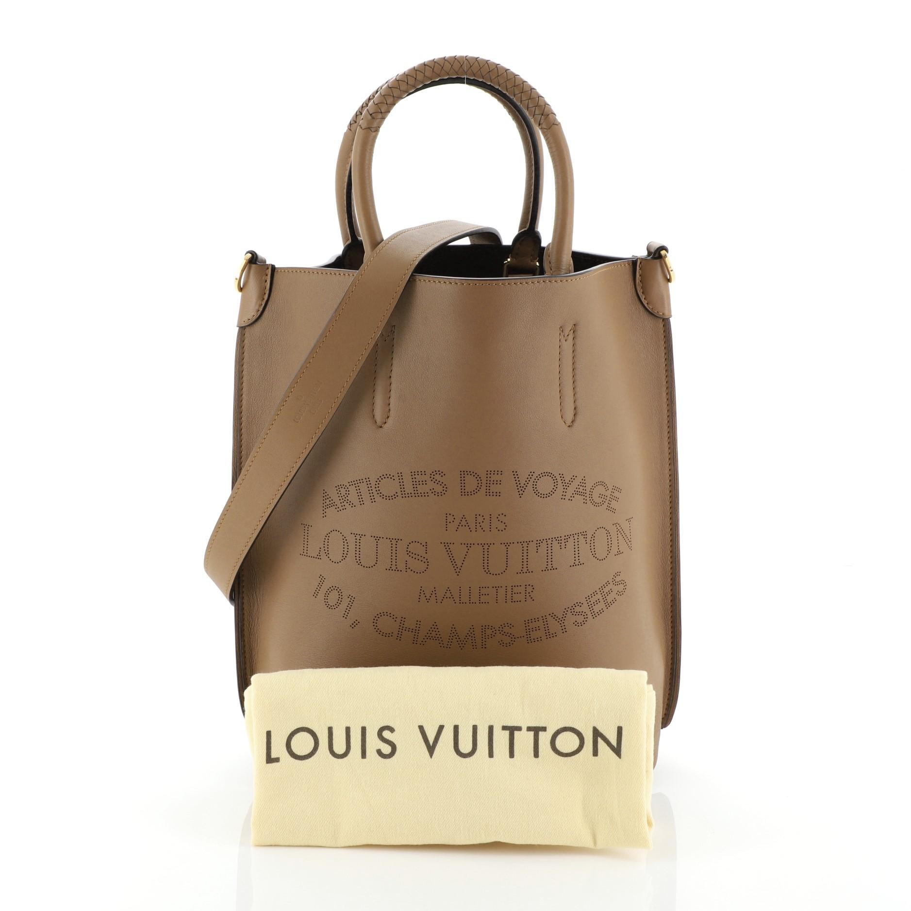 This Louis Vuitton Flore Handbag Leather MM, crafted from brown leather, features braided leather handles, heritage signature Articles de Voyage pinpoint perforated design and gold-tone hardware. Its claw clasp closure opens to a brown leather and