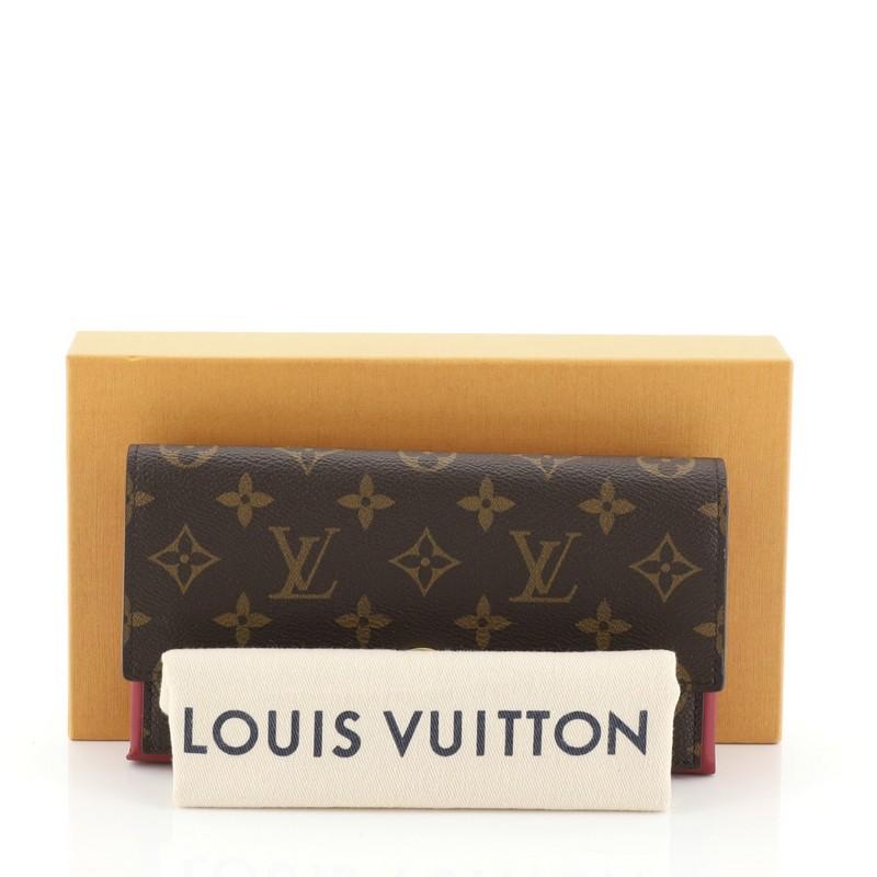 This Louis Vuitton Flore Wallet Monogram Canvas, crafted in brown monogram coated canvas, features a flower press stud and gold-tone hardware. Its press lock closure opens to a brown canvas and purple leather interior with multiple card slots, zip