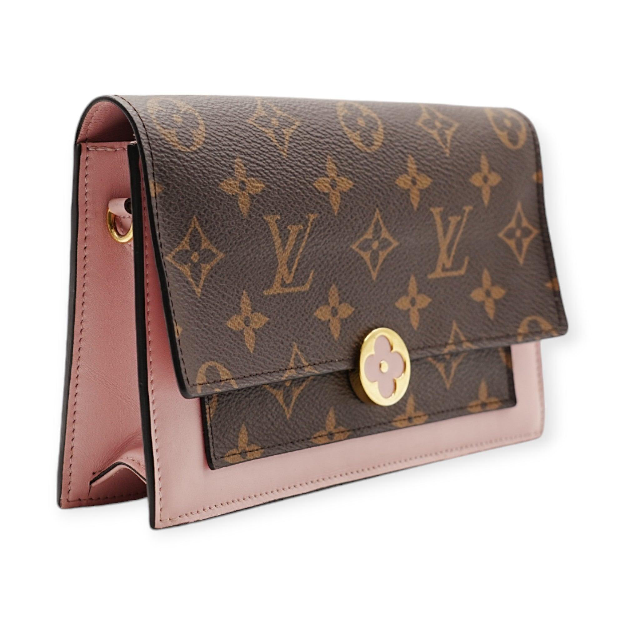 The Louis Vuitton Flore WOC features a distinctive clasp shaped like a four-leaf clover, adding a whimsical touch to its design. With playful pink patchwork detailing, this elegant bag combines functionality and style, making it a perfect accessory