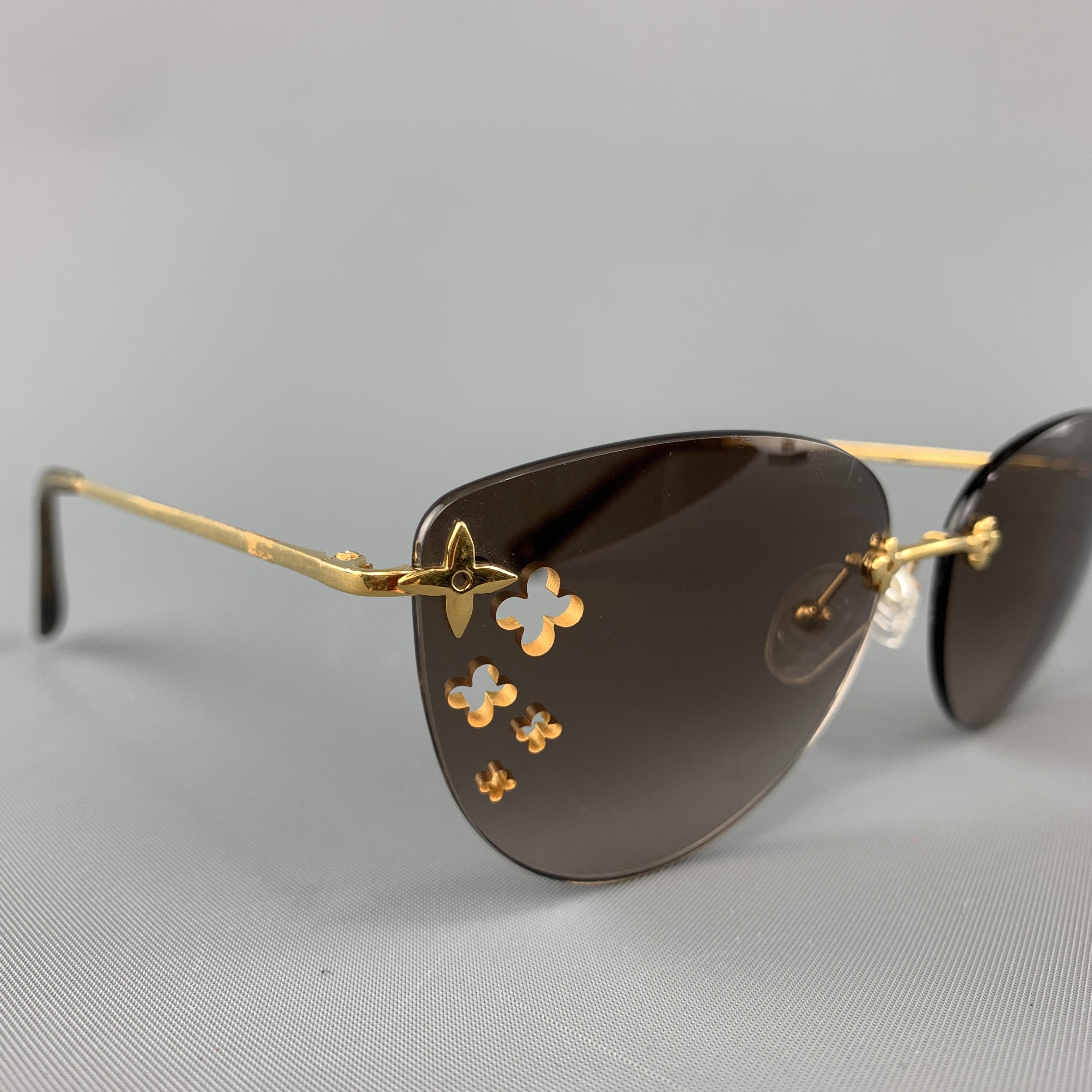 LOUIS VUITTON sunglasses feature brown ombre rimless lenses with flower cutouts and gold tone monogram charm hardware. Minor wear. Made in France.

Very Good Pre-Owned Condition.
Marked: Z0051U 

Length: 14 cm.
Width: 5 cm.