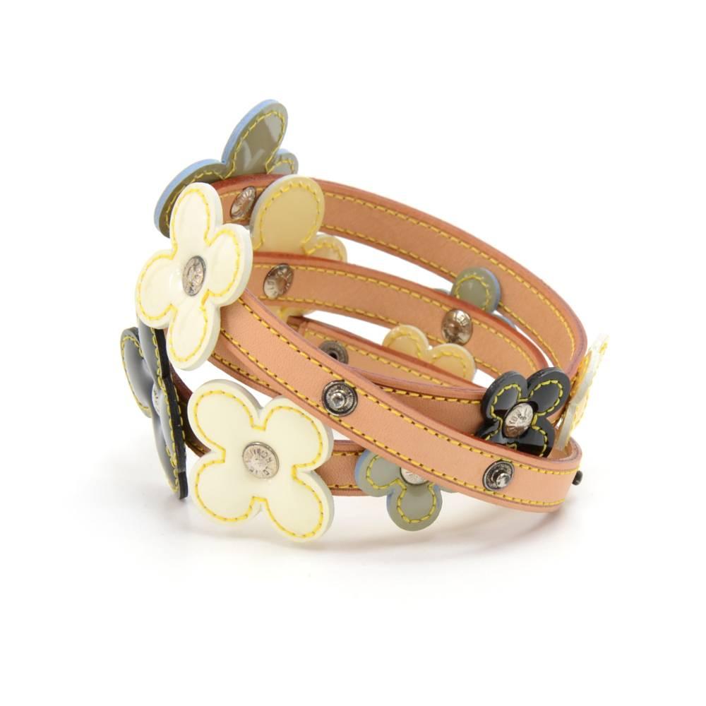 This is Louis Vuitton leather belt with vernis leather flowers.  This is a lovely belt with black, yellow, and light blue vernis leather flowers in various sizes decorating the belt. It can be closed with its many push-stud buttons to a few