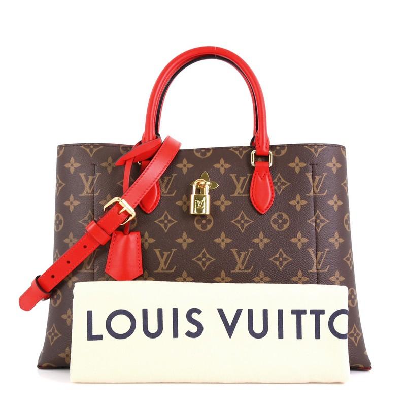 This Louis Vuitton Flower Tote Monogram Canvas, crafted in brown monogram coated canvas, features dual rolled leather handles, monogram flower padlock, and gold-tone hardware. It opens to a red microfiber interior with a center zip compartment and