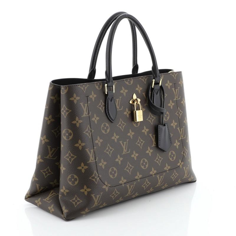 This Louis Vuitton Flower Tote Monogram Canvas, crafted in brown monogram coated canvas, features dual rolled leather handles, monogram flower padlock, and gold-tone hardware. It opens to a black microfiber interior with a center zip compartment and