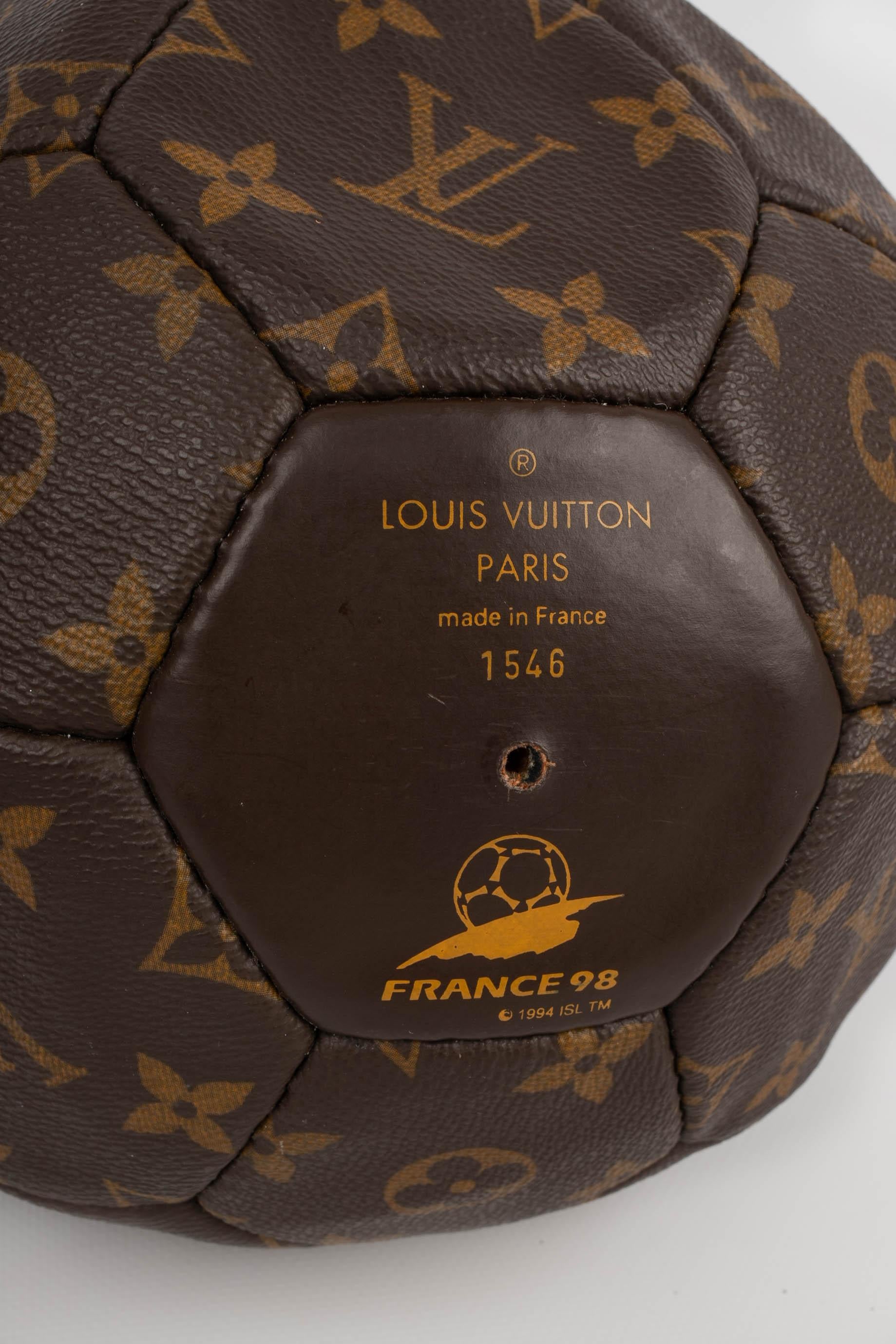 LOUIS VUITTON - Monogram Canvas-Fußball mit einem Netz aus Naturleder. Limitierte Auflage - Fußballweltmeisterschaft 1998. Artikel, der mit einer von einem Sachverständigen ausgestellten Konformitätsbescheinigung verkauft wird.

Bedingung:
Sehr