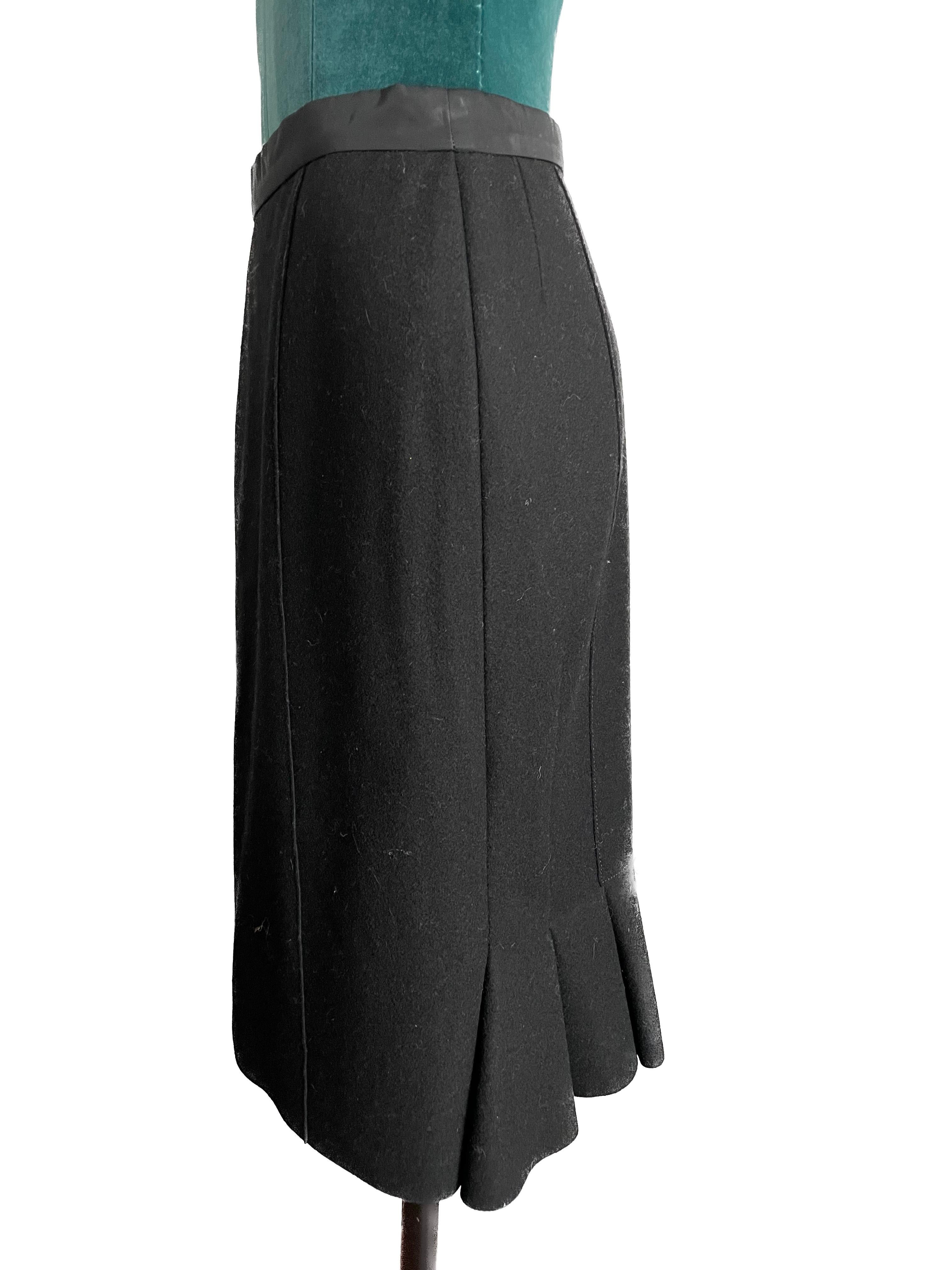 The Louis Vuitton Black Pencil Skirt with Flair Detail in the back is a masterful blend of classic sophistication and contemporary flair, showcasing the renowned craftsmanship and design prowess of the iconic fashion house. This impeccably tailored