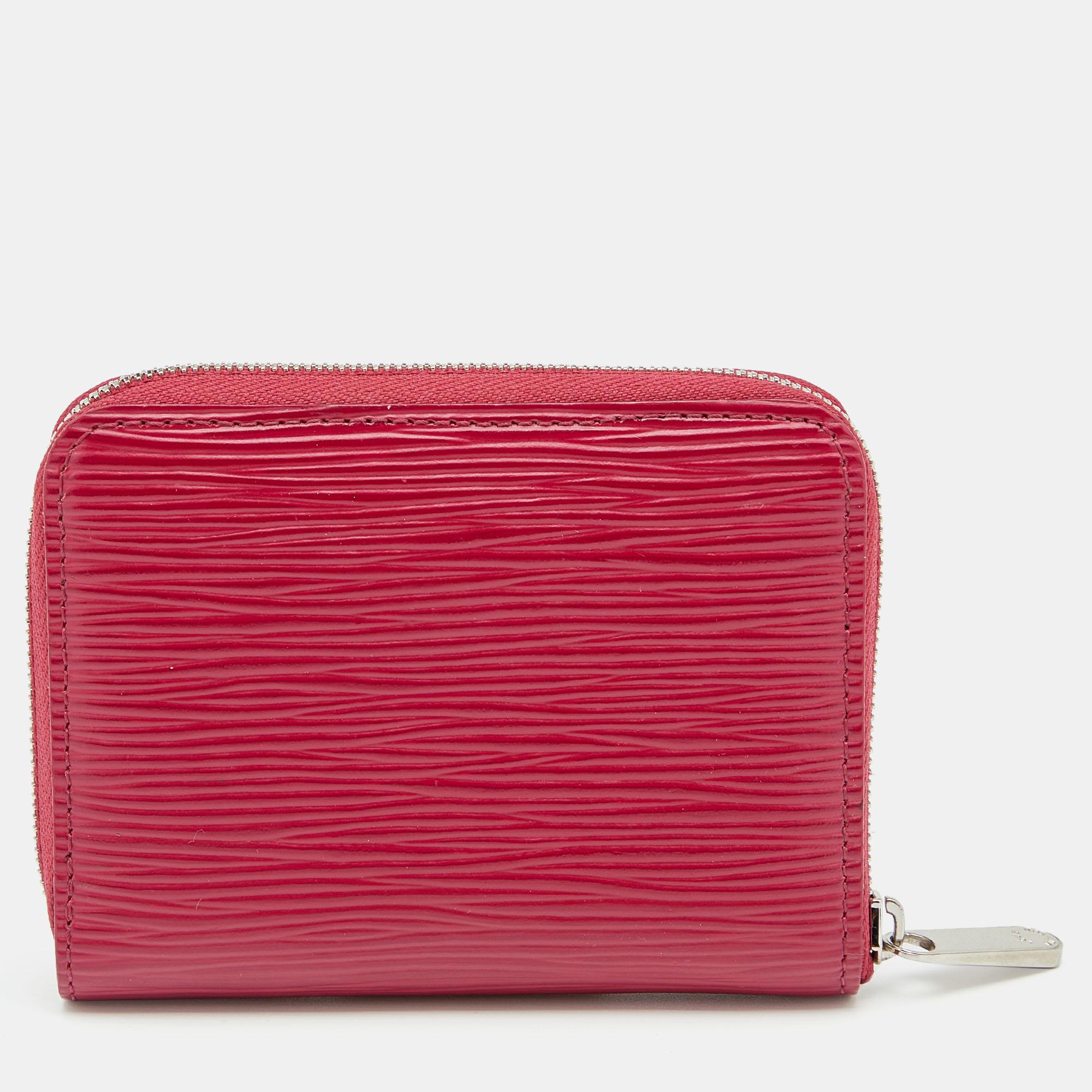 This Louis Vuitton Zippy coin purse is conveniently designed for everyday use. Crafted from fuchsia Epi leather, the purse has a zip closure that opens to reveal multiple slots for you to neatly arrange your cards and coins.